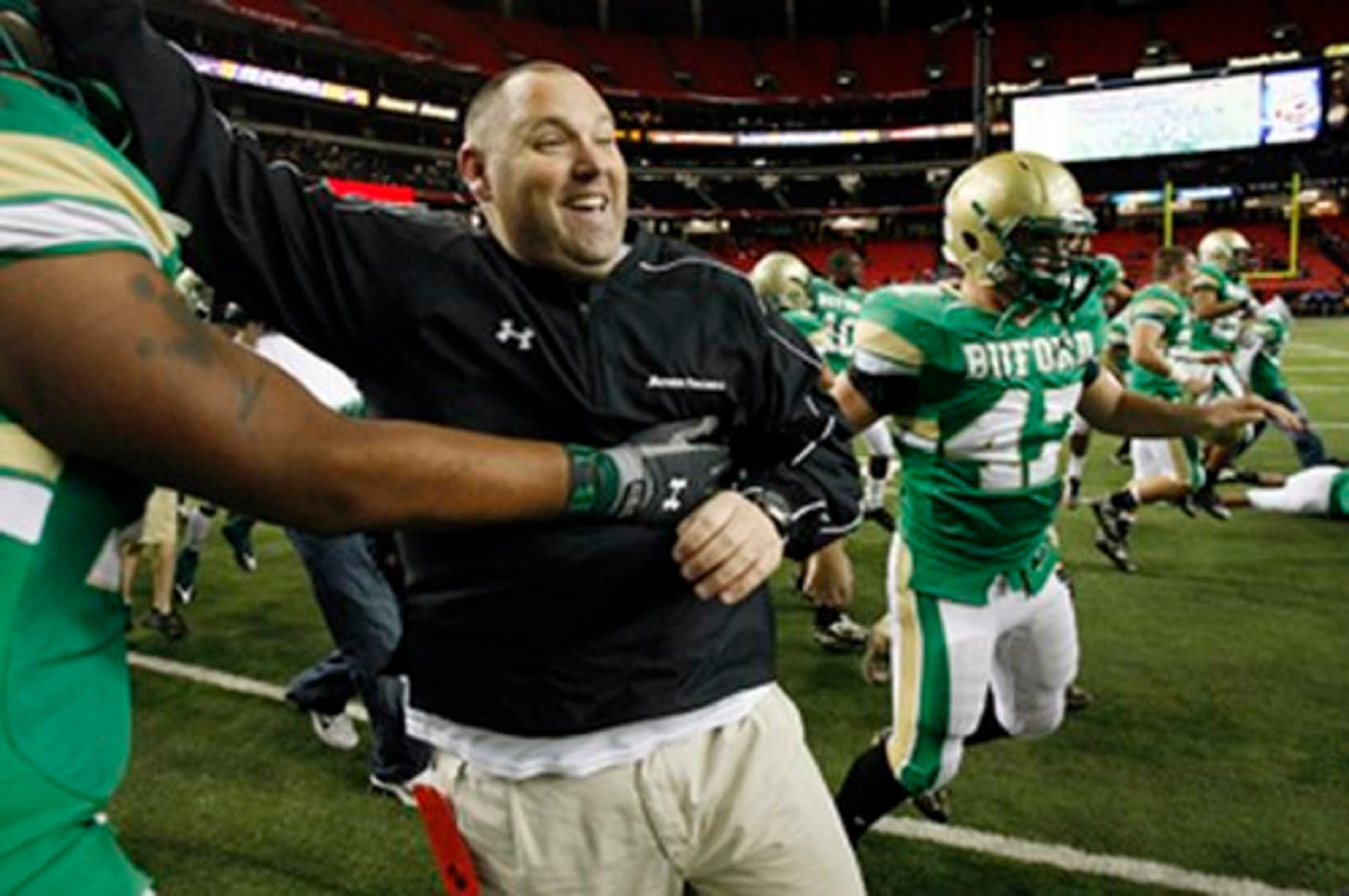 Buford coach Jess Simpson celebrates the Wolves' 13-10 win over Calhoun in the Class AA State Championship Game Friday at the Georgia Dome.