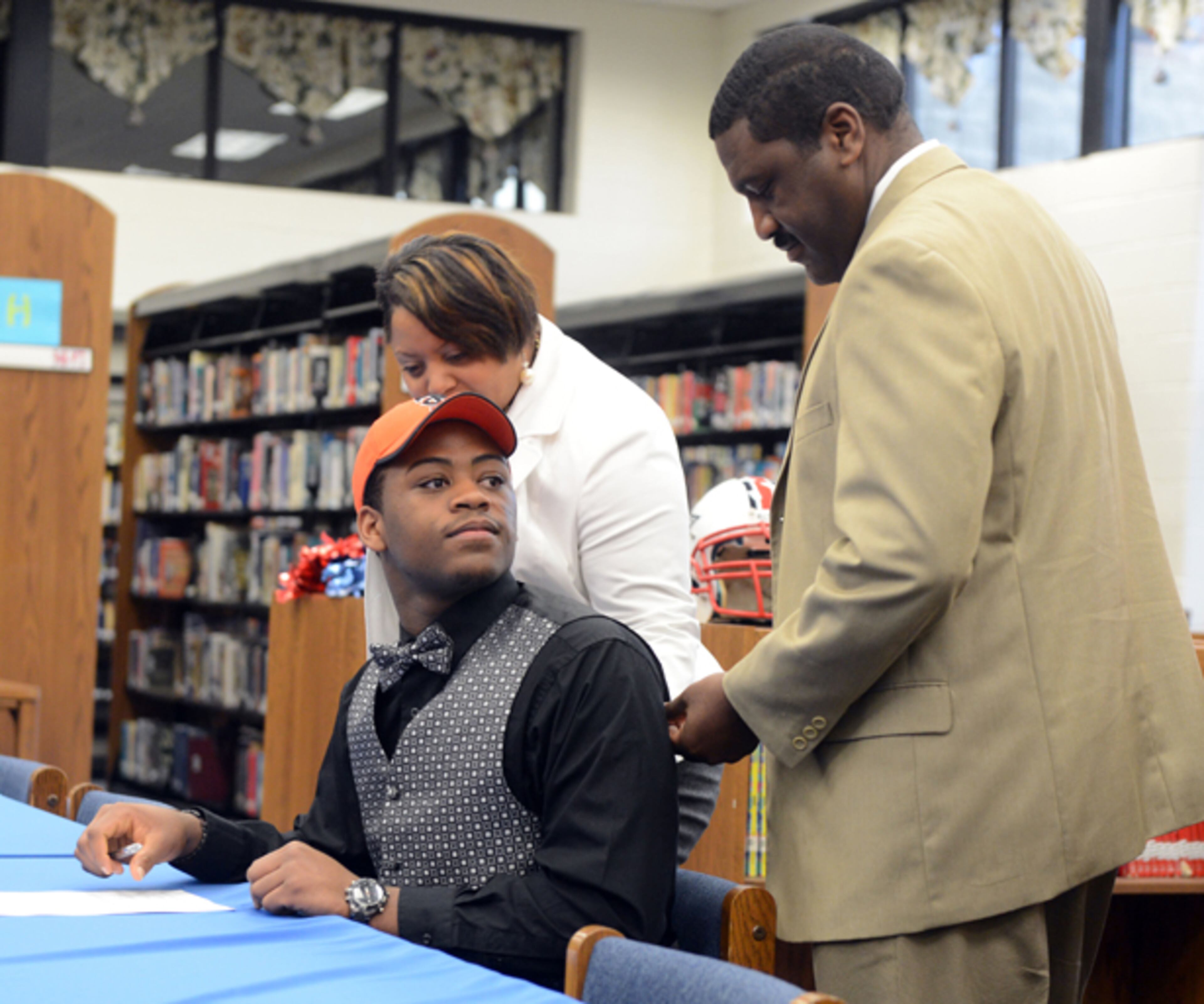Zach Lane looks at his dad, Gavin Lane, while his mom, Lashell, offers encouragement after he signed with Tusculum College.