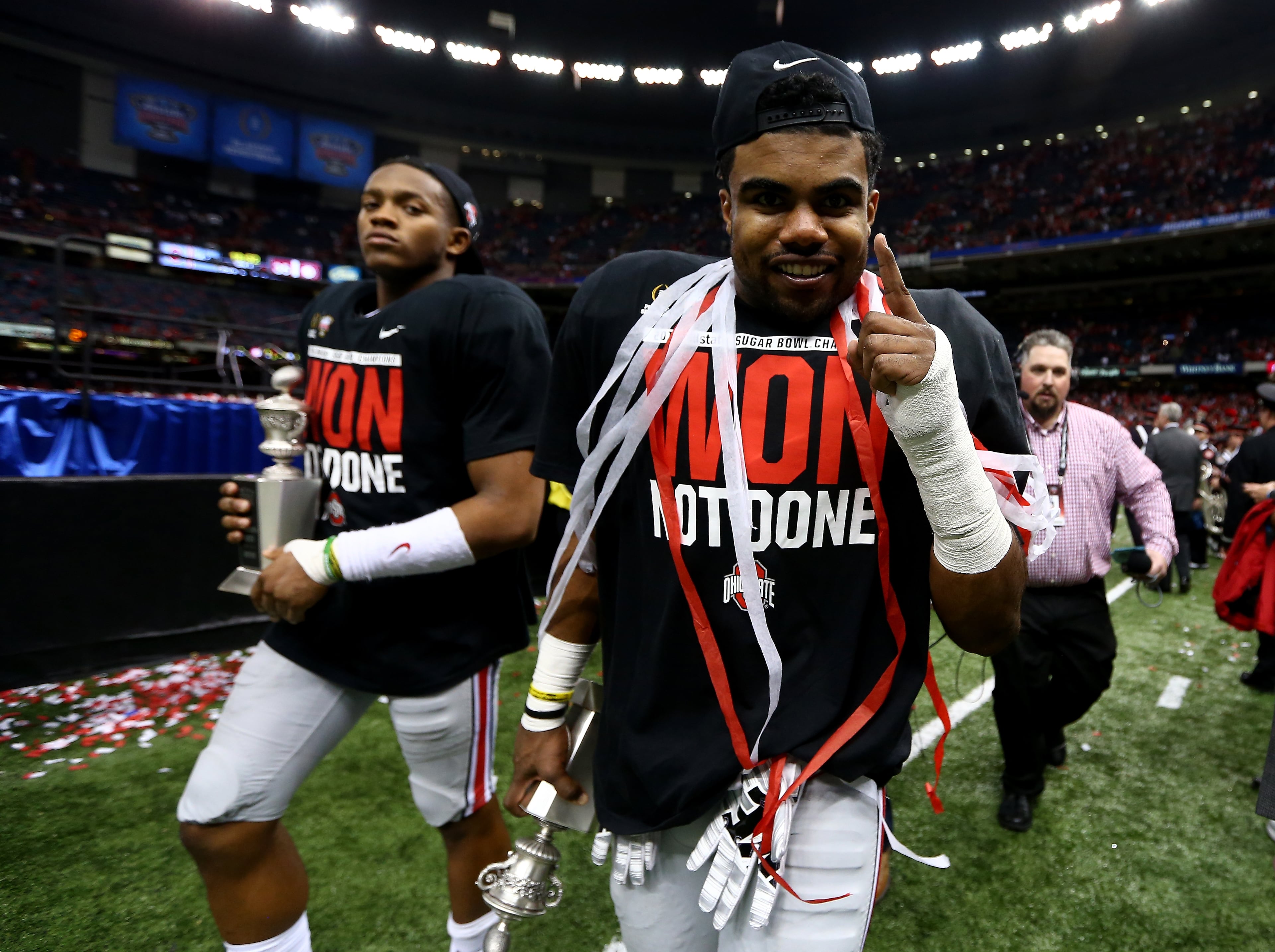 Darron Lee #43 and Ezekiel Elliott #15 of the Ohio State Buckeyes celebrate with their trophies after defeating the Alabama Crimson Tide in the All State Sugar Bowl at the Mercedes-Benz Superdome on January 1, 2015 in New Orleans, Louisiana. The Ohio State Buckeyes defeated the Alabama Crimson Tide 42 to 35. (Photo by Streeter Lecka/Getty Images)