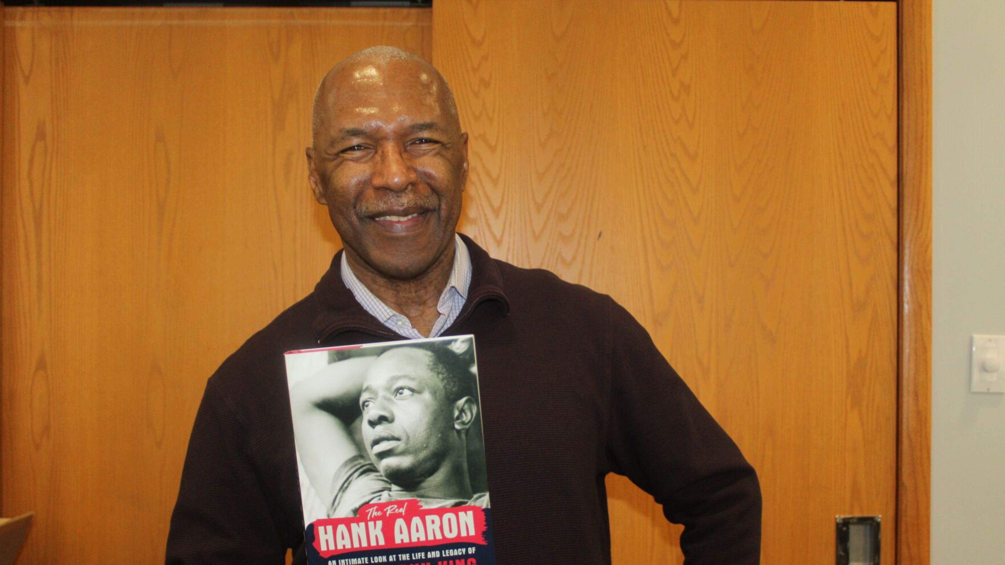 Longtime Atlanta sports writer Terence Moore holds a copy of his book, "The Real Hand Aaron: An Intimate Look at the Life and Legacy of the Home Run King," on Saturday at the Smyrna Public Library. (Photo Courtesy of Brian McKeithan)
