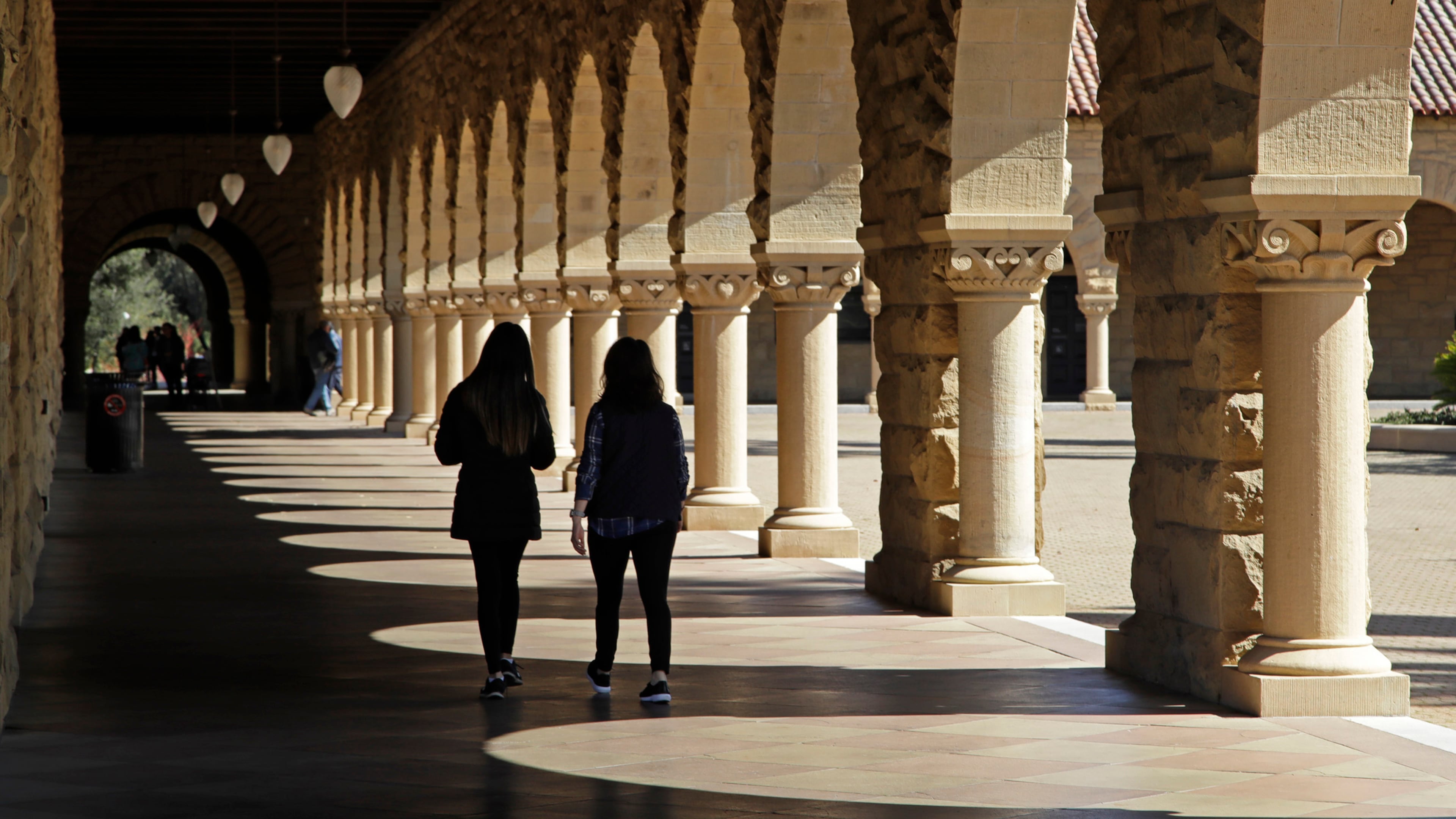 FILE - Students walk through the Stanford University campus, March 14, 2019, in Santa Clara, Calif. (AP Photo/Ben Margot, File)