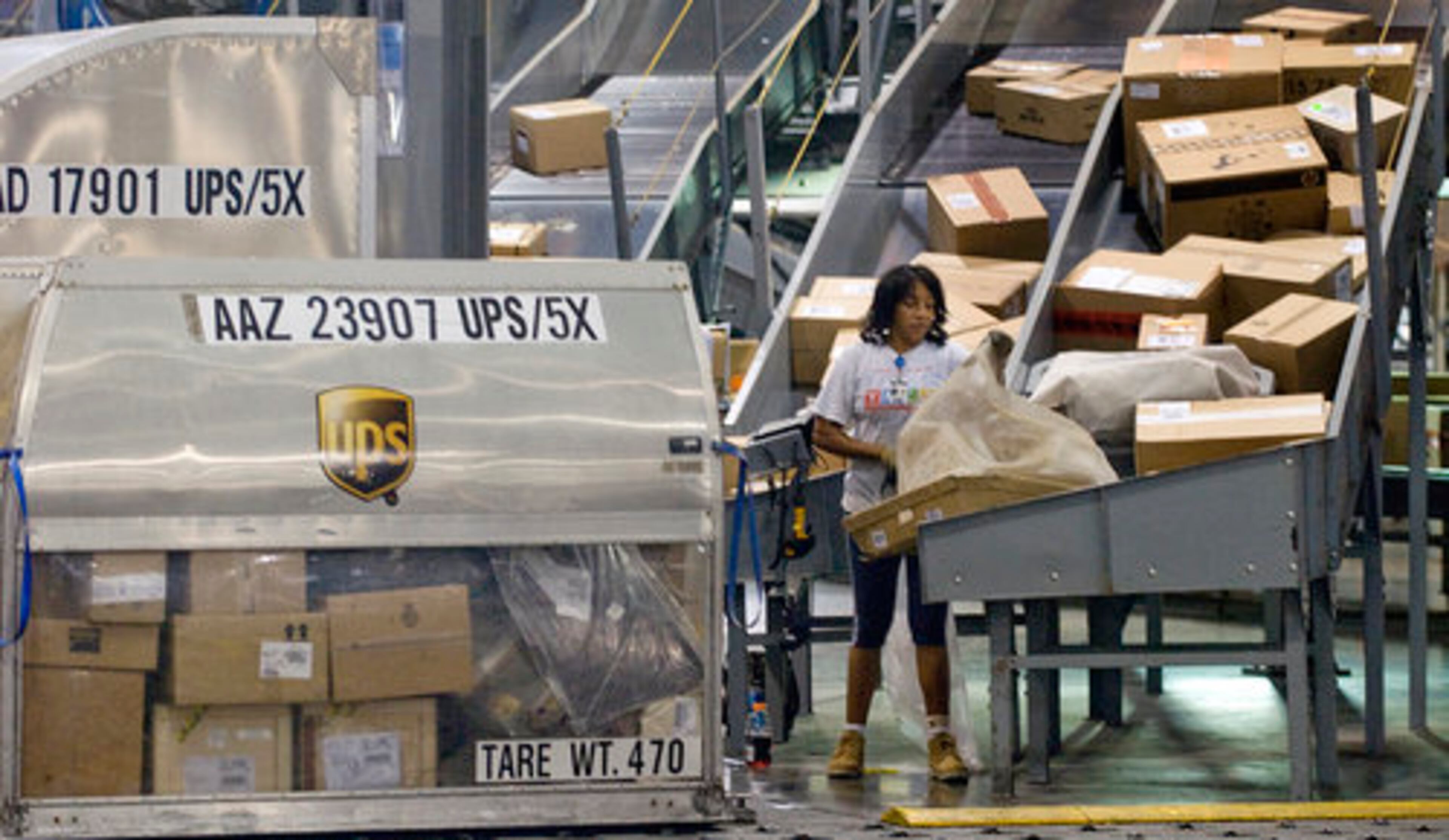 Inside the sorting facility, Andrea Shirley put packages them inside the UPS cans, for shipment to another location. The miles of UPS conveyor belts are computer operated and automatically route packages to the correct plane for shipment.