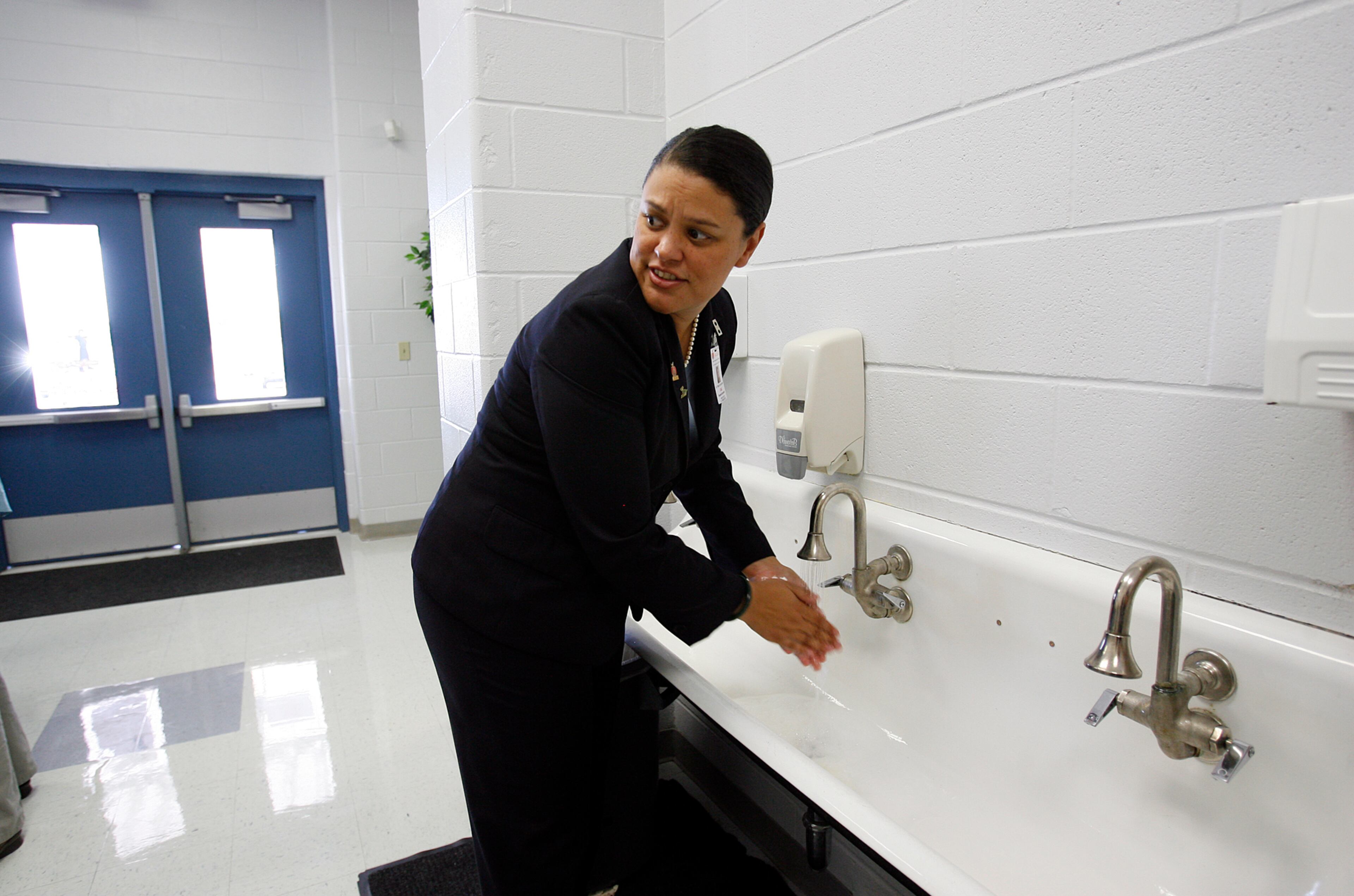 New AISD Superintendent Dr. Meria Carstarphen looks back at students at Casey Elementary as she washes her hands before heading into the cafeteria to eat lunch on Monday, August 24, 2009. Hand washing and using hand sanitizers were being encouraged as schools attempted to slow the spread of the H1N1 virus.