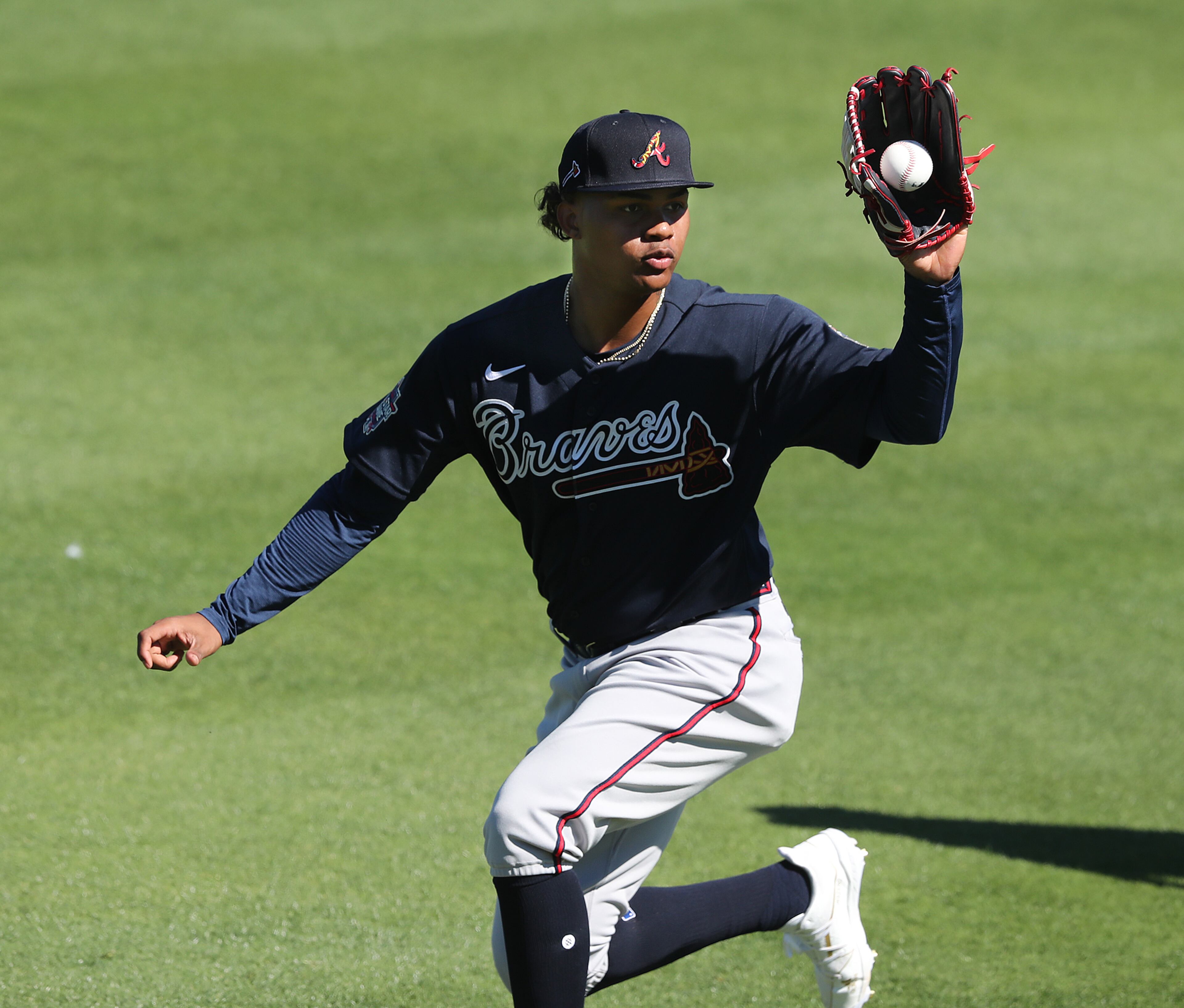 Outfielder Cristian Pache catches a ball while fielding during team practice Thursday, Feb. 25, 2021, at CoolToday Park in North Port, Fla. (Curtis Compton/Curtis.Compton@ajc.com)