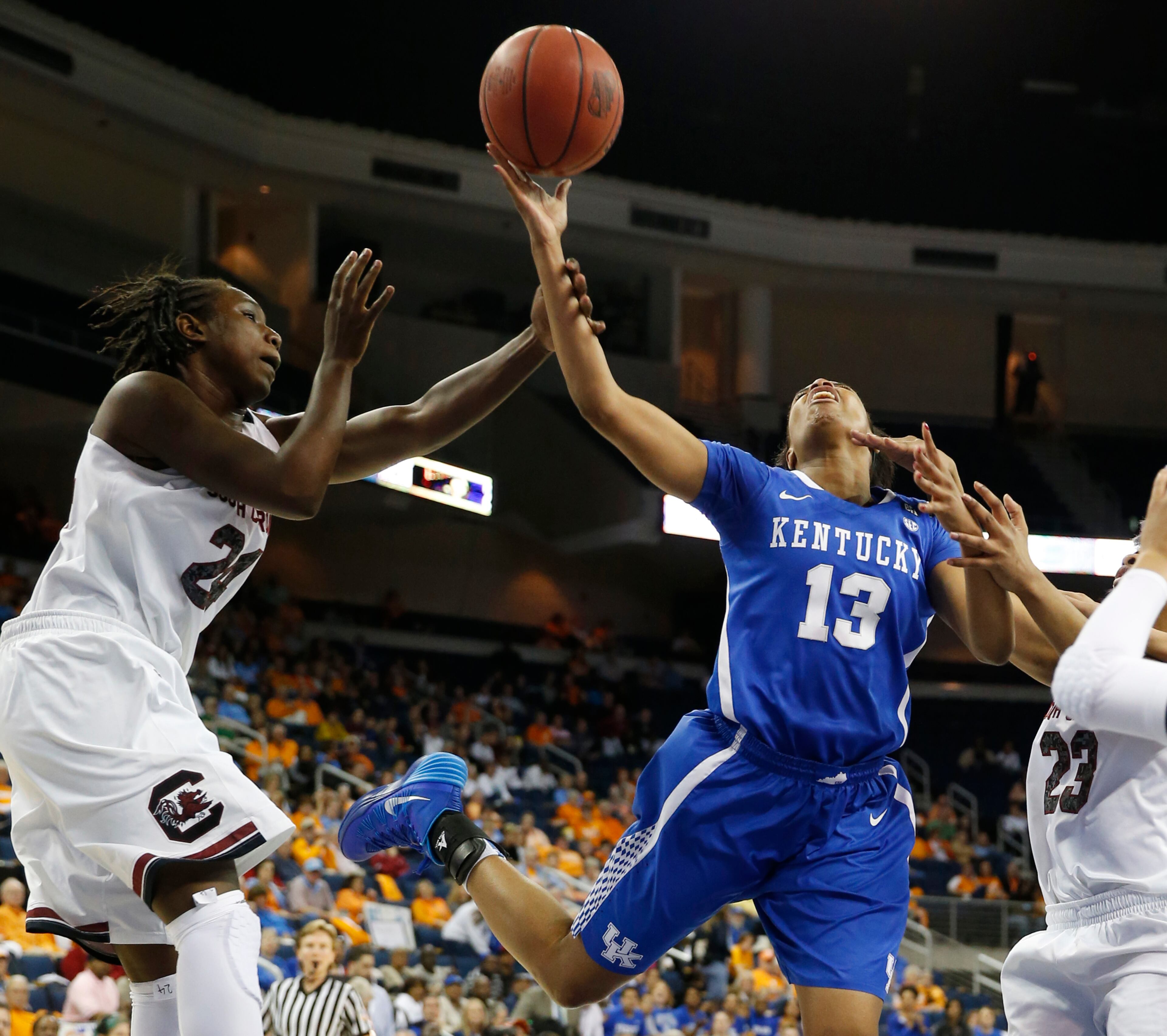 Kentucky guard Bria Goss (13) is fouled as she drives between South Carolina forward Aleighsa Welch (24) in the first half of a fourth-round women's Southeastern Conference tournament NCAA college basketball game Saturday, March 8, 2014, in Duluth, Ga.
