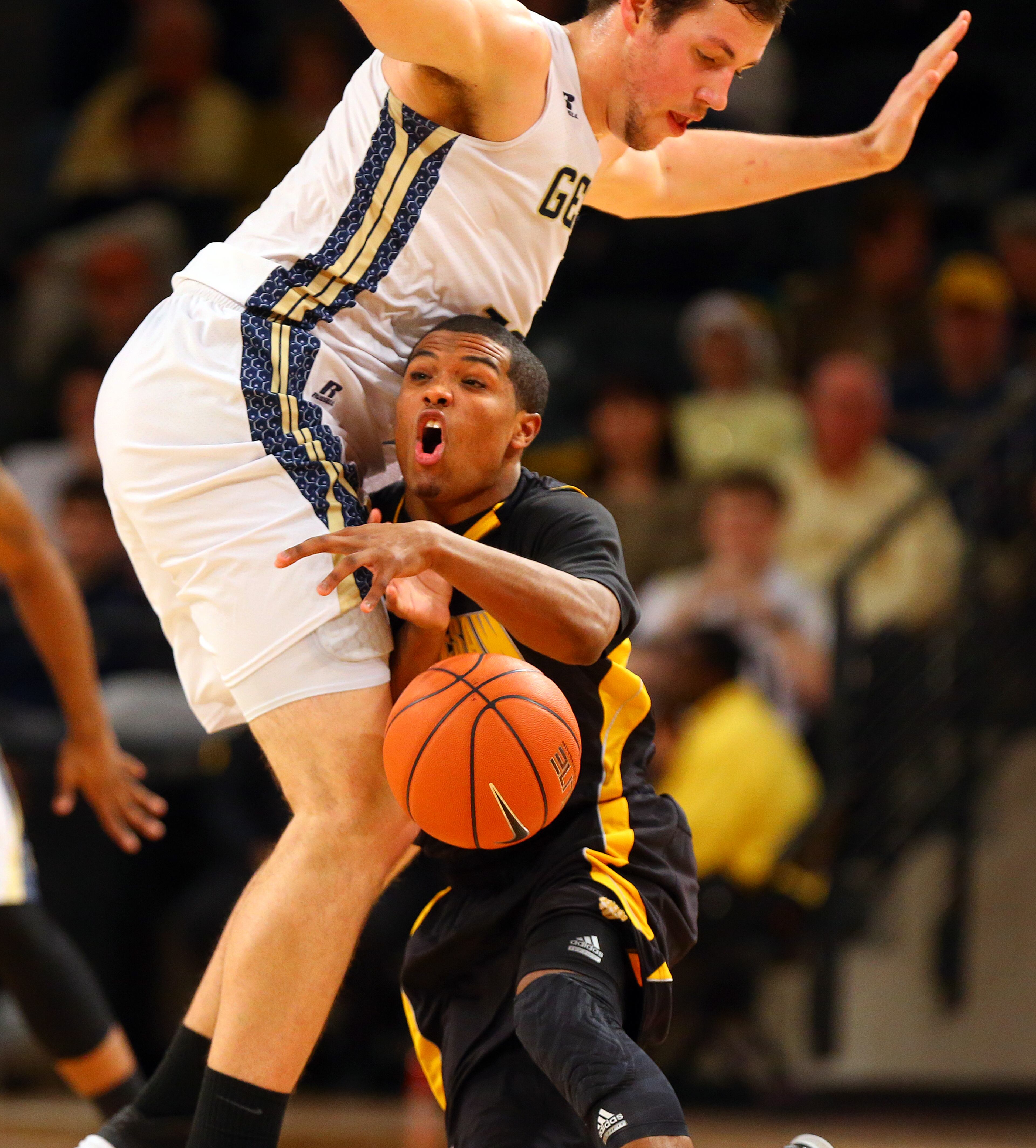 Kennesaw State Owls guard Yonel Brown turns the ball over as he collides with Georgia Tech defender cneter Daniel Miller during the first half of a college basketball game on Monday, Dec. 16, 2013, in Atlanta.