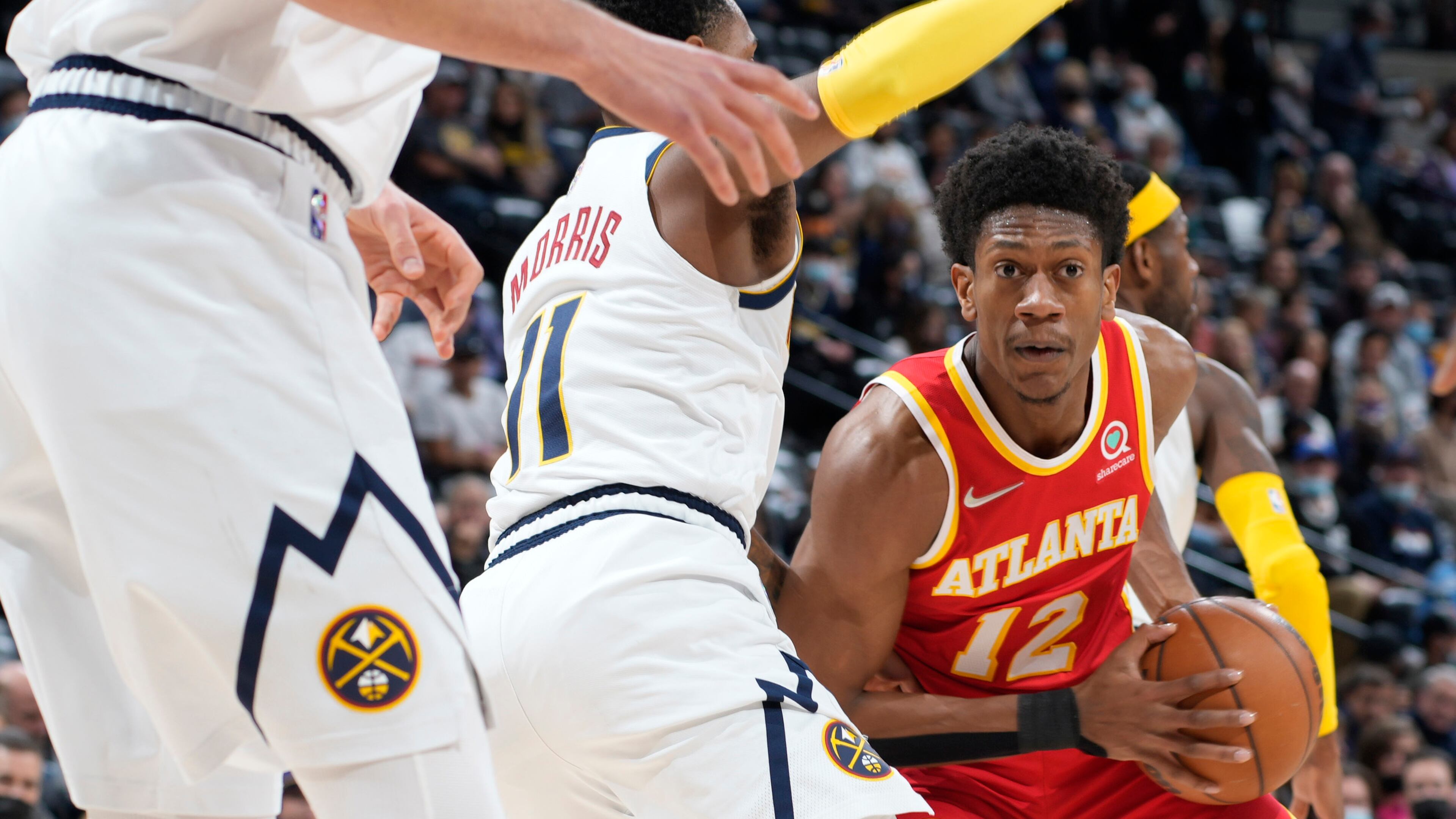 Atlanta Hawks forward De'Andre Hunter, right, looks to pass the ball as Denver Nuggets guard Monte Morris defends during the first half of an NBA basketball game Friday, Nov. 12, 2021, in Denver. (AP Photo/David Zalubowski)