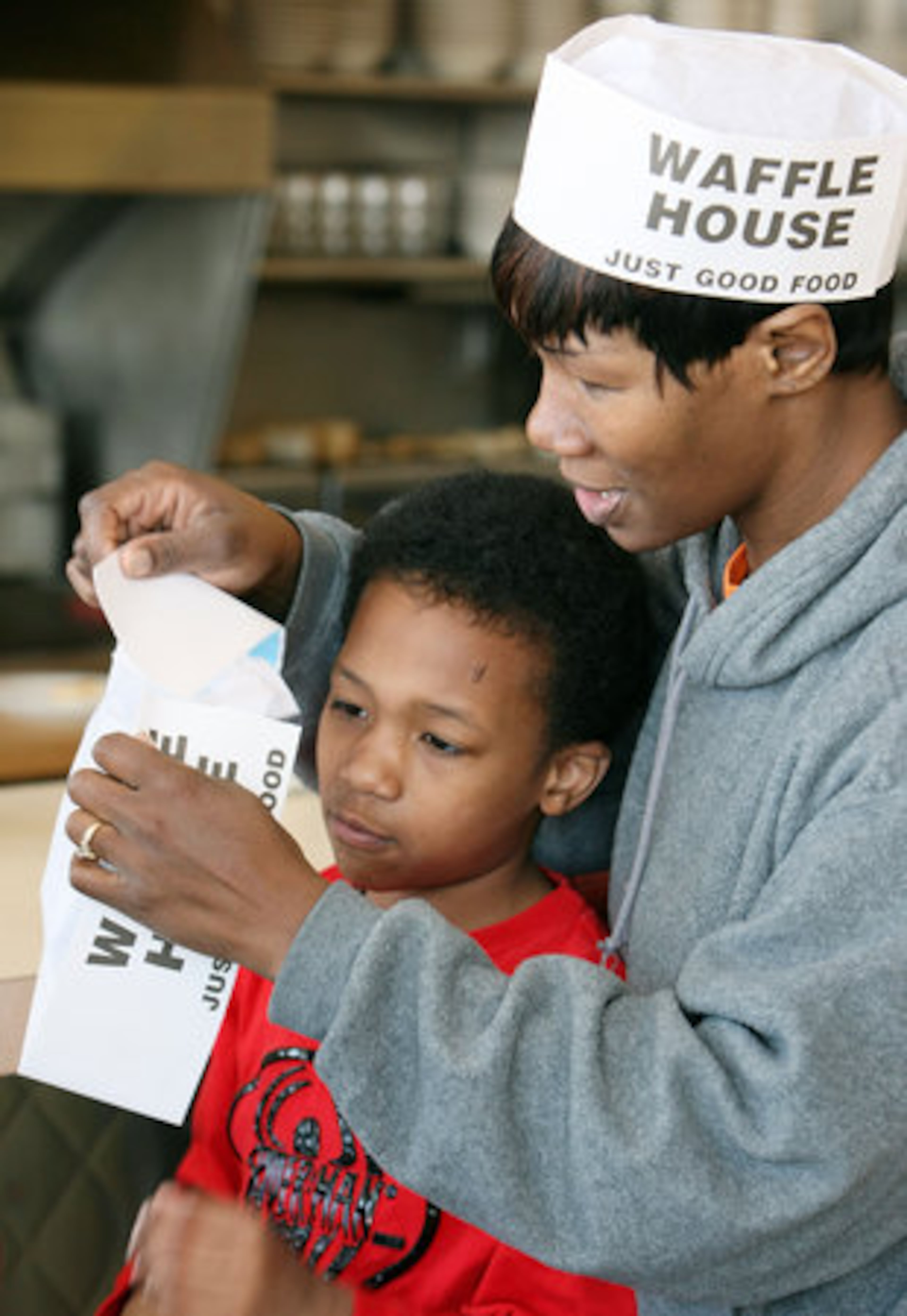 Davetta Rouse helps her 7-year-old son, Caleb, with his hat.