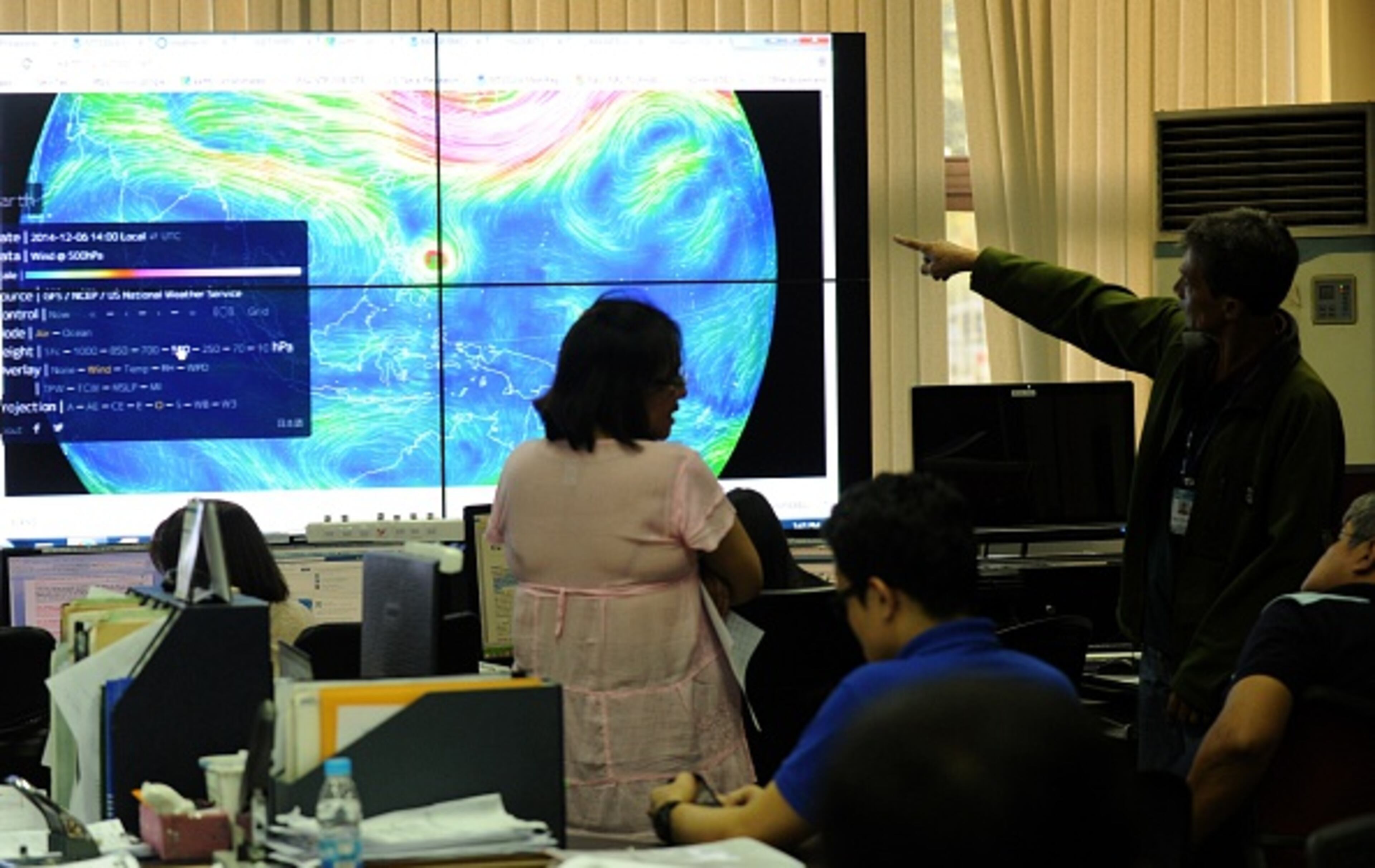 Meteorologists from the Philippine Atmospheric, Geophysical and Astronomical Services Administration (PAGASA) monitor and plot the direction of super typhoon Hagupit at PAGASA in suburban Manila on December 4, 2014. A super typhoon gained strength on December 4 as it tracked towards the Philippines, threatening more devastation for mostly poor communities where thousands of people have died in an annual tirade of mega storms. AFP PHOTO / Jay DIRECTO (Photo credit should read JAY DIRECTO/AFP/Getty Images)