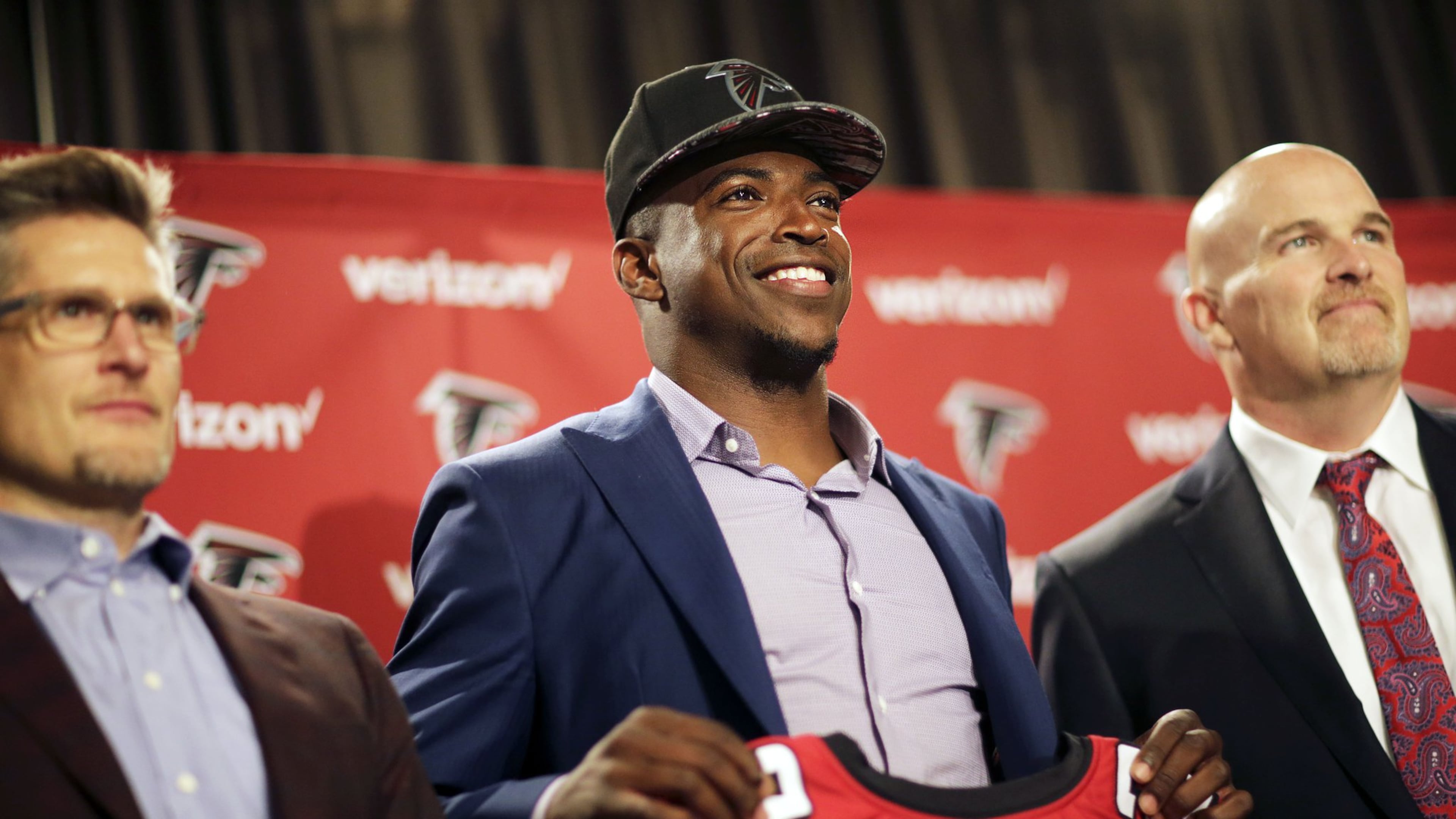Atlanta Falcons first round draft pick Keanu Neal, center, poses for a photo with his jersey and general manager Thomas Dimitroff, left, and head coach Dan Quinn at the football team’s practice facility Friday, April 29, 2016, in Flowery Branch, Ga. (AP Photo/David Goldman)