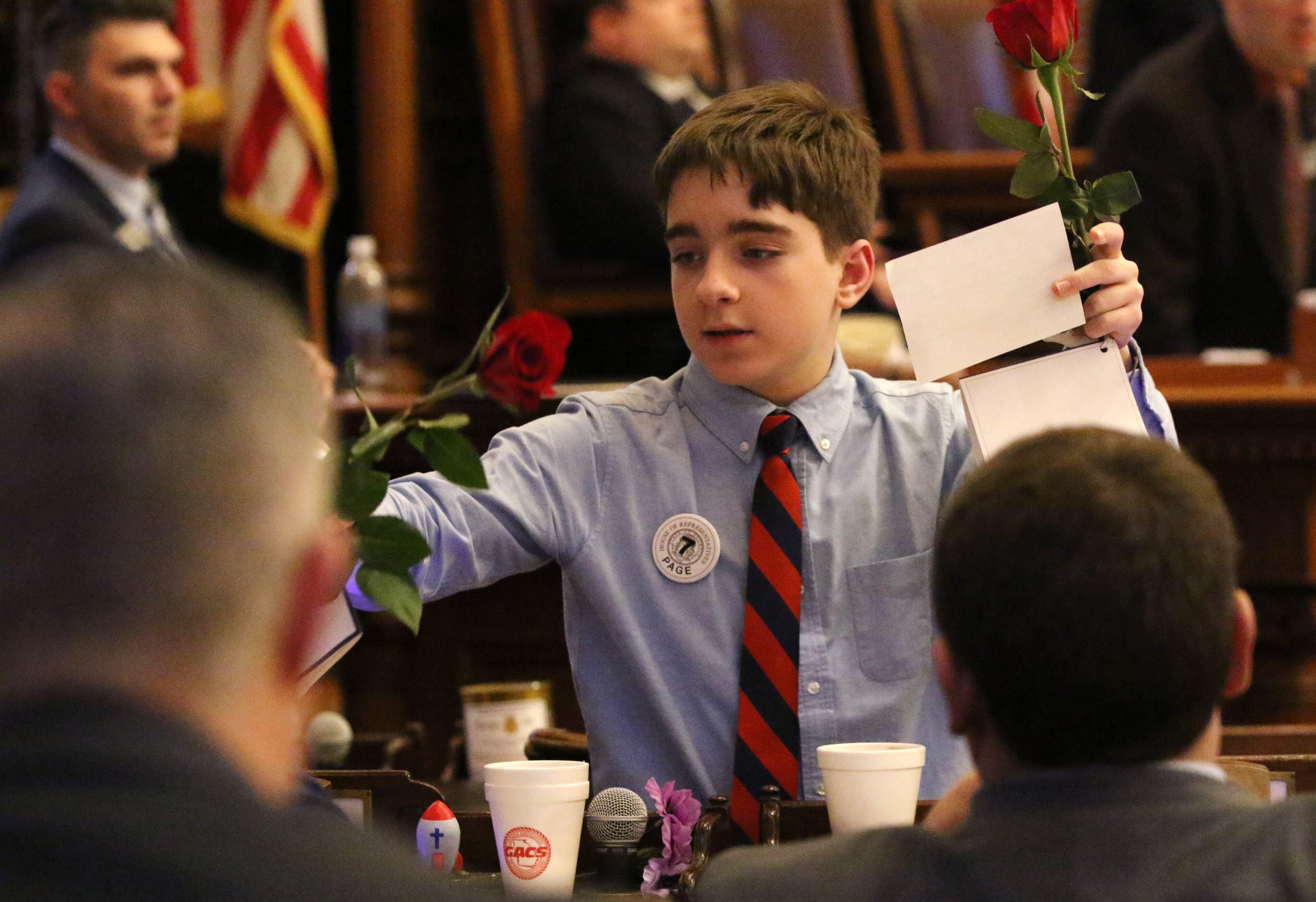 3/7/19 - Atlanta - A page hands out roses to representatives at the Georgia State Capitol in Atlanta, Georgia on Thursday, March 7, 2019. HB 282 passed. EMILY HANEY / emily.haney@ajc.com