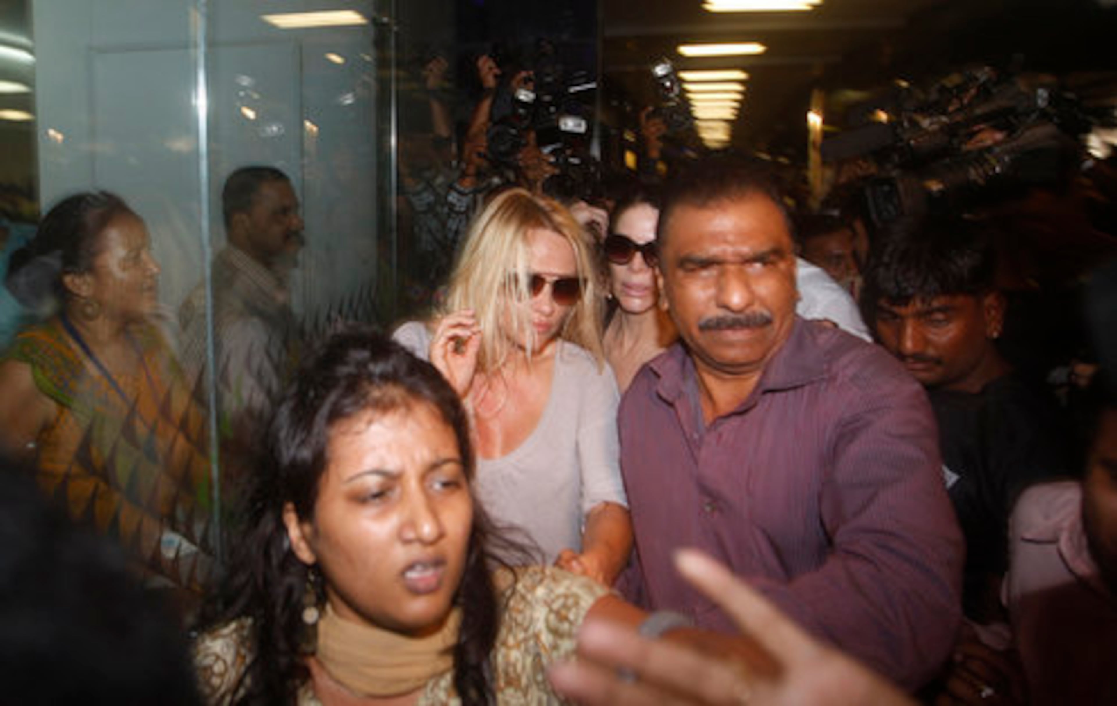 Pamela Anderson is greeted by a throng of reporters and television cameras as she arrives Monday in Chhatrapati Shivaji International Airport in Mumbai, India, for a three-day guest appearance on reality TV show "Big Boss" - India's version of "Big Brother."