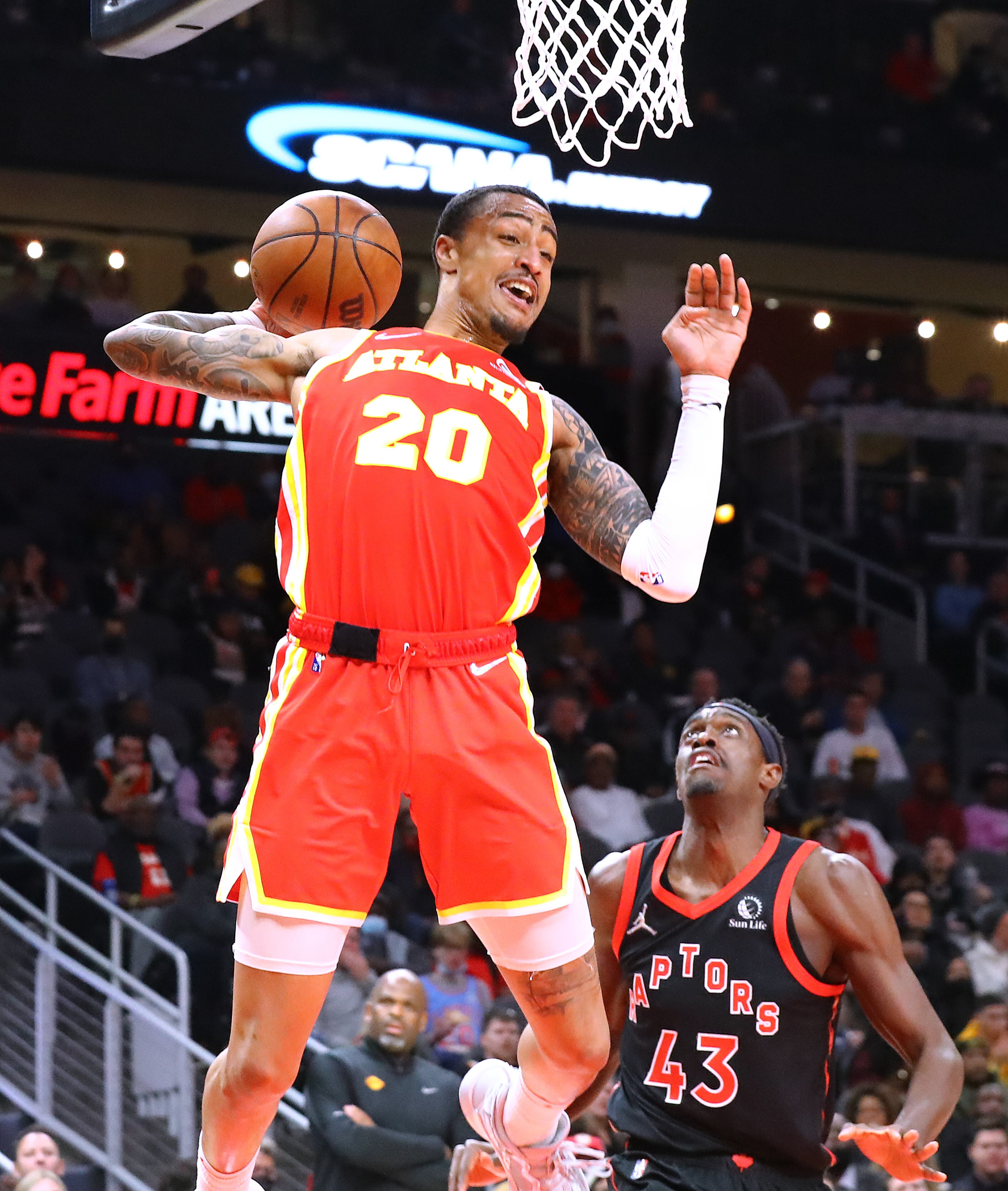 013122 Atlanta: Atlanta Hawks forward John Collins grabs a rebound over Toronto Raptors Pascal Siakam in an NBA basketball game on Monday, Jan. 31, 2022, in Atlanta. “Curtis Compton / Curtis.Compton@ajc.com”`