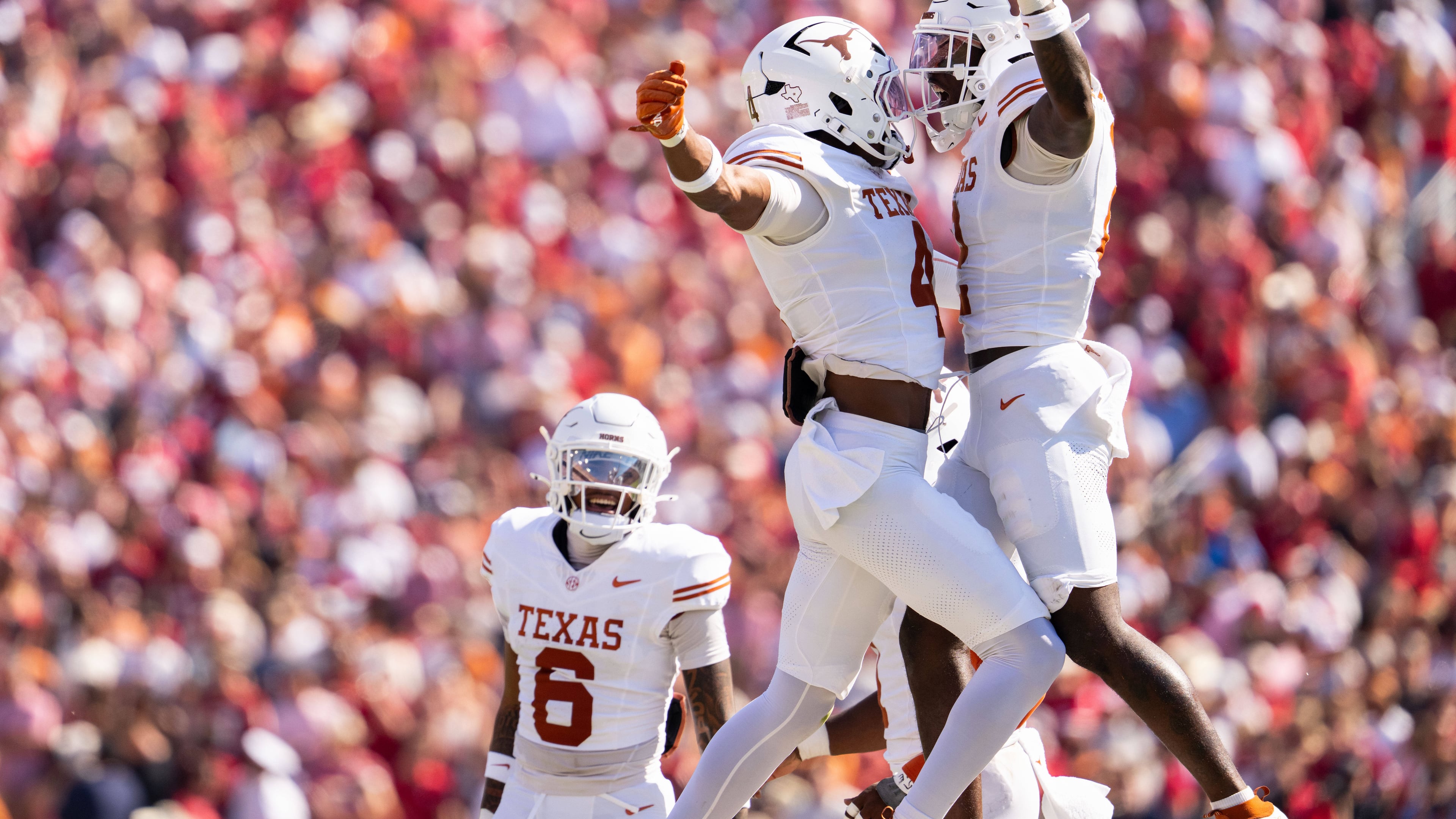 Texas Longhorns defensive backs Jelani McDonald, left, and Derek Williams Jr. celebrate a defensive stop as defensive back Kobe Black (6) looks on during the first half of an NCAA college football game against Oklahoma, Saturday, Oct. 10, 2026, in Dallas. (AP Photo/Jeffrey McWhorter)