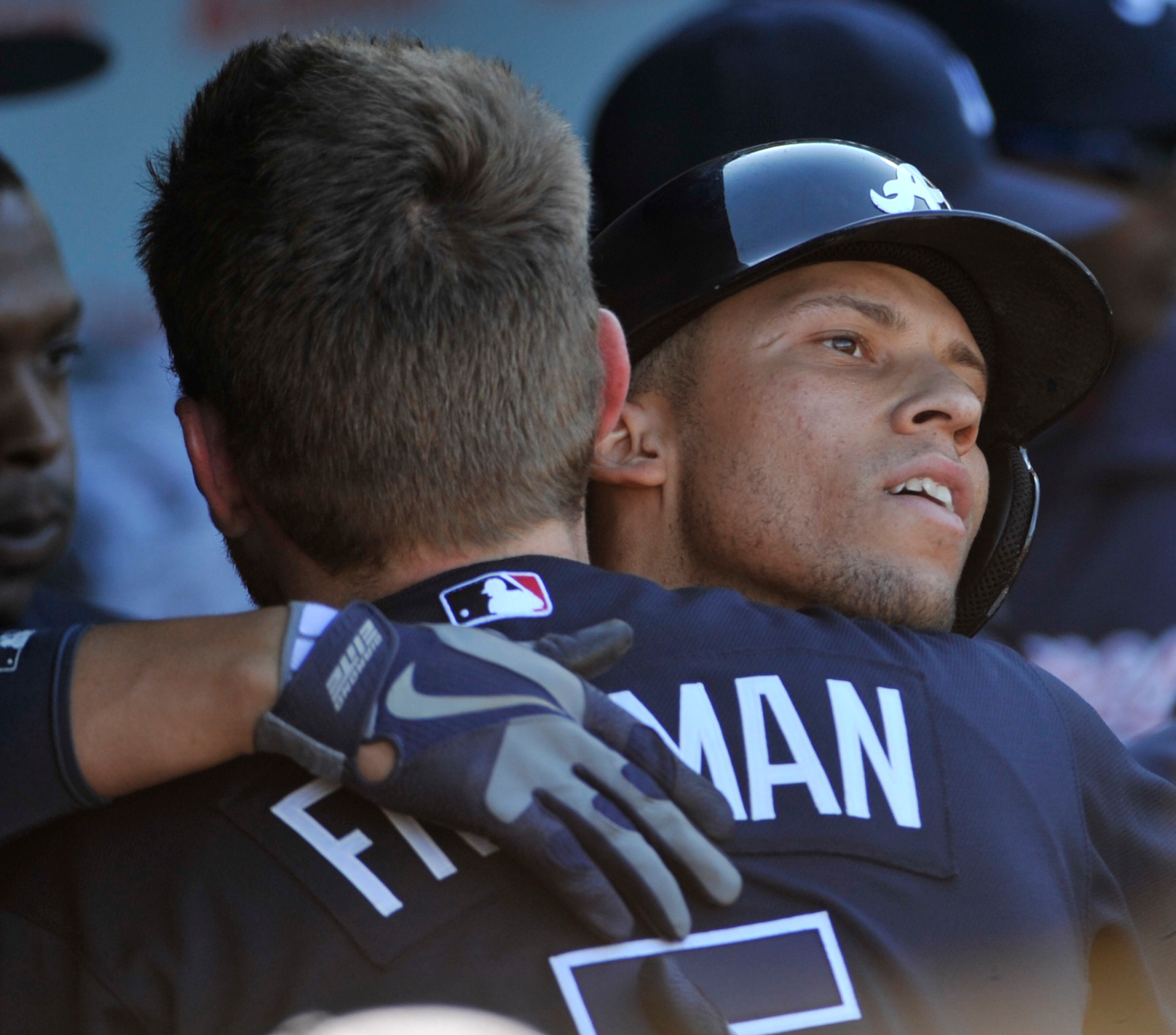 Andrelton Simmons #19 of the Atlanta Braves is greeted by Freddie Freeman #5 after hitting a two-run homer against the Chicago Cubs during the eighth inning on Sept. 22, 2013 at Wrigley Field in Chicago, Illinois. The Braves won 5-2.