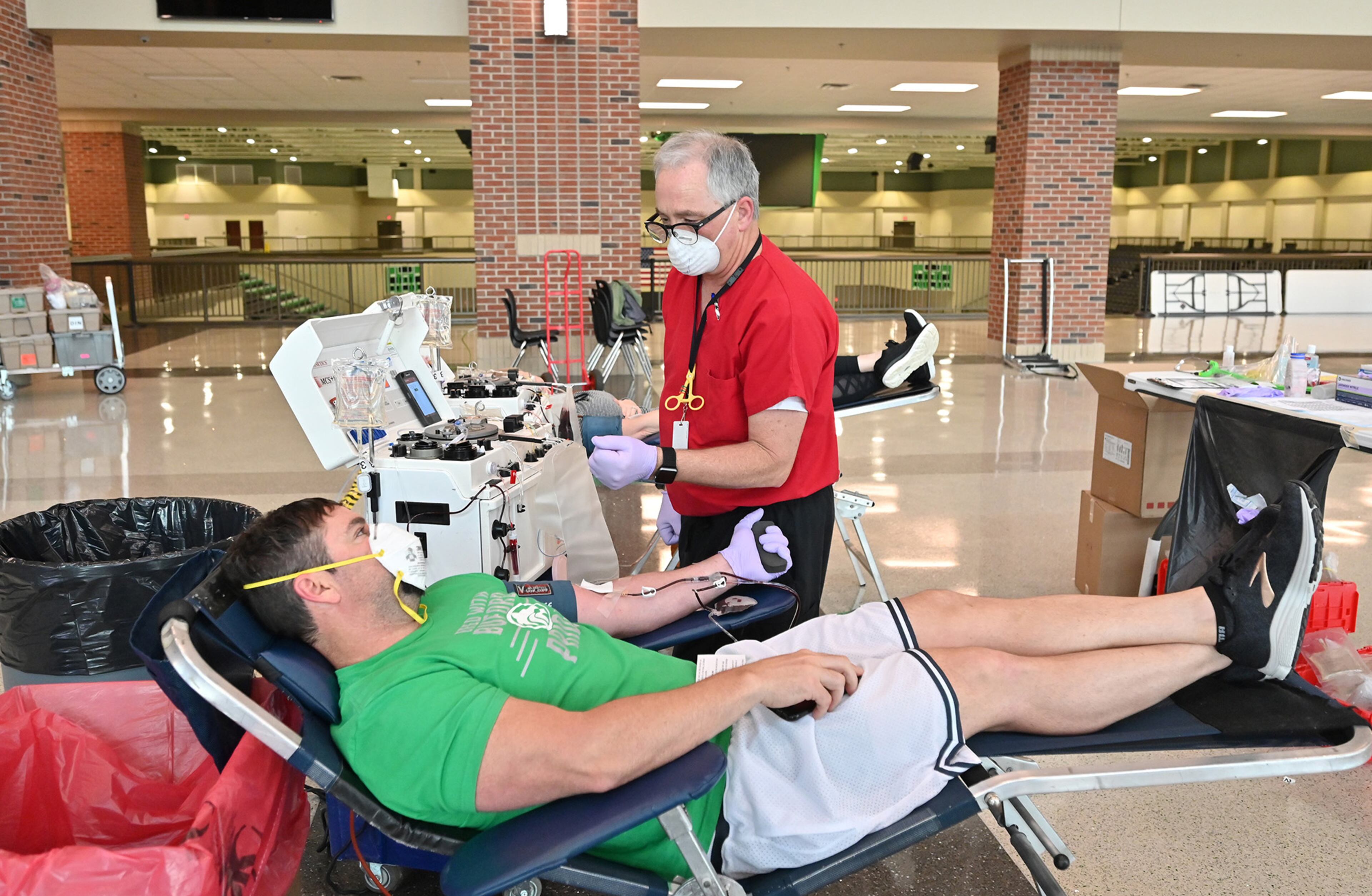 March 31, 2020 Buford - Scott Veale, with Red Cross, sets up Brandon Hastings (foreground) for a double donation during Buford City SchoolsâÃô annual Blood Drive at Buford Arena on Tuesday, March 31, 2020. With social distancing and extra measures to keep people safe from the coronavirus, blood supplies are getting dangerously low. Buford City Schools is hosting a blood drive. They are checking the temperature of everyone who enters and have other precautions in place. (Hyosub Shin / Hyosub.Shin@ajc.com)