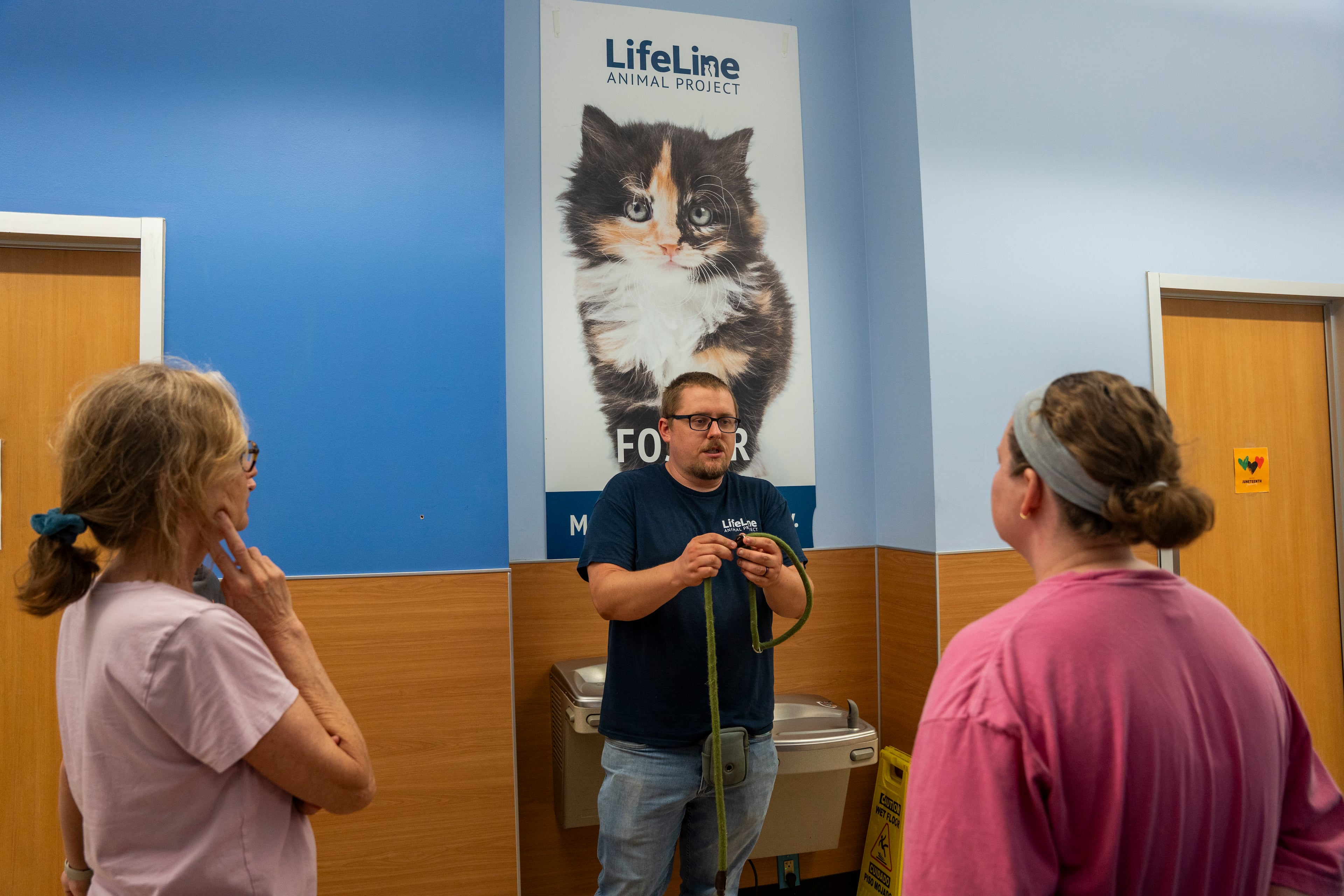A volunteer teaches visitors how to use a leash at the DeKalb Animal Shelter on Tuesday, July 1, 2025, in Chamblee. (Olivia Bowdoin for the AJC)