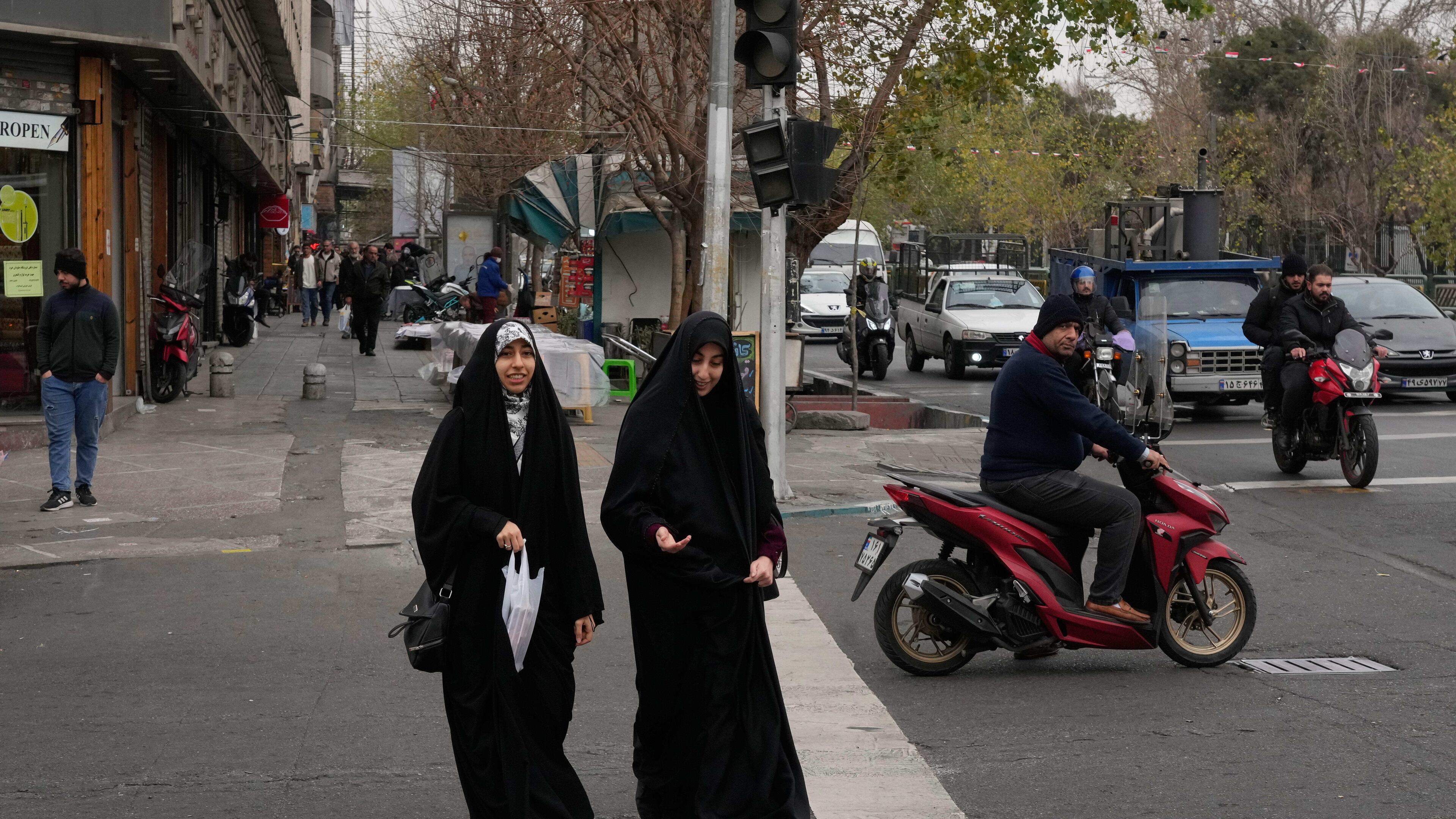Women cross an intersection in downtown Tehran, Iran, Thursday, Jan. 15, 2026. (AP Photo/Vahid Salemi)
