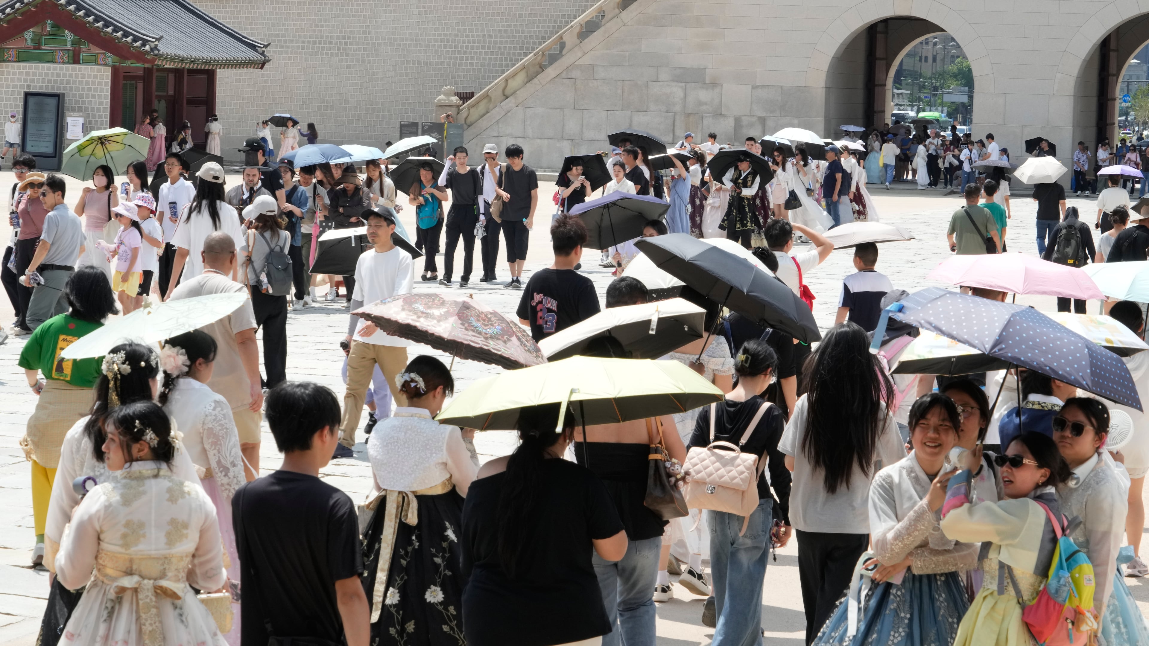 Visitors hold umbrellas to avoid sunshine at the Gyeongbok Palace in Seoul, South Korea, Wednesday, Aug. 5, 2026. (AP Photo/Ahn Young-joon)