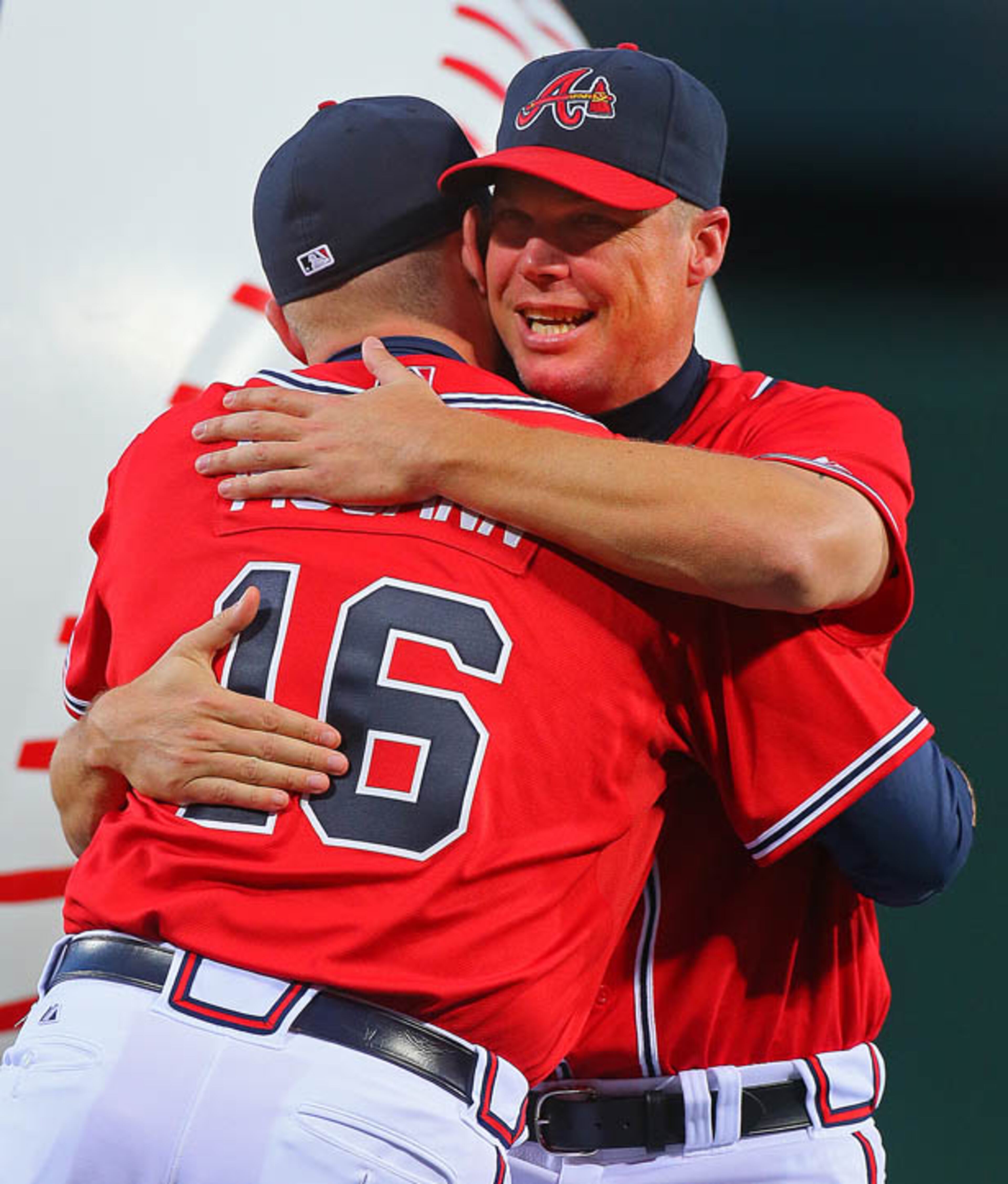 Braves catcher Brian McCann gives Chipper Jones a hug after addressing the crowd and announcing the team was giving Jones a commemorative billiards table as retirement gift.