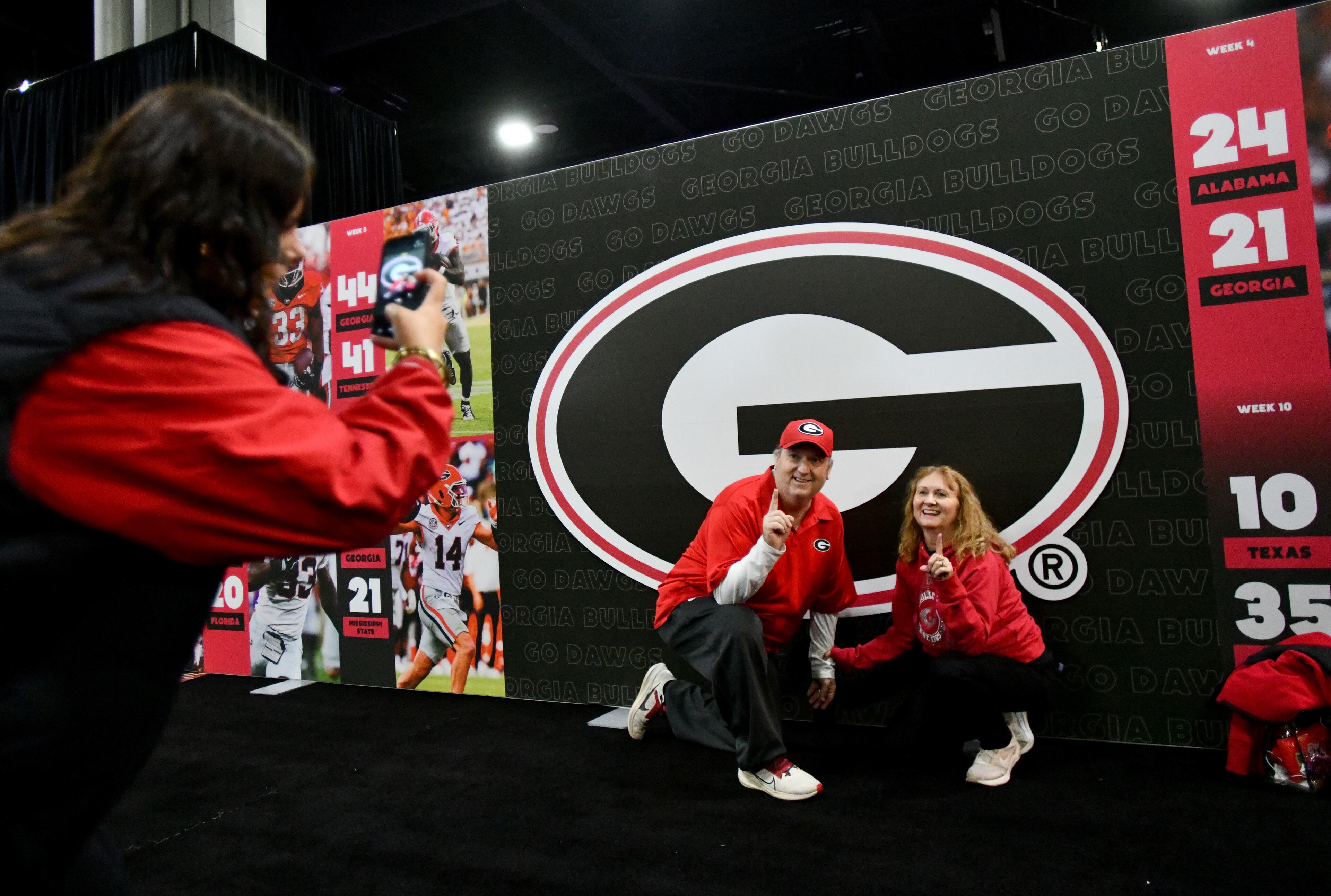 Georgia fans pose in front “G” sign at The Dr Pepper SEC FanFare ahead of the SEC Championship football game between Georgia and Alabama, Saturday, Dec. 6, 2025 in Atlanta. (Hyosub Shin/AJC)
