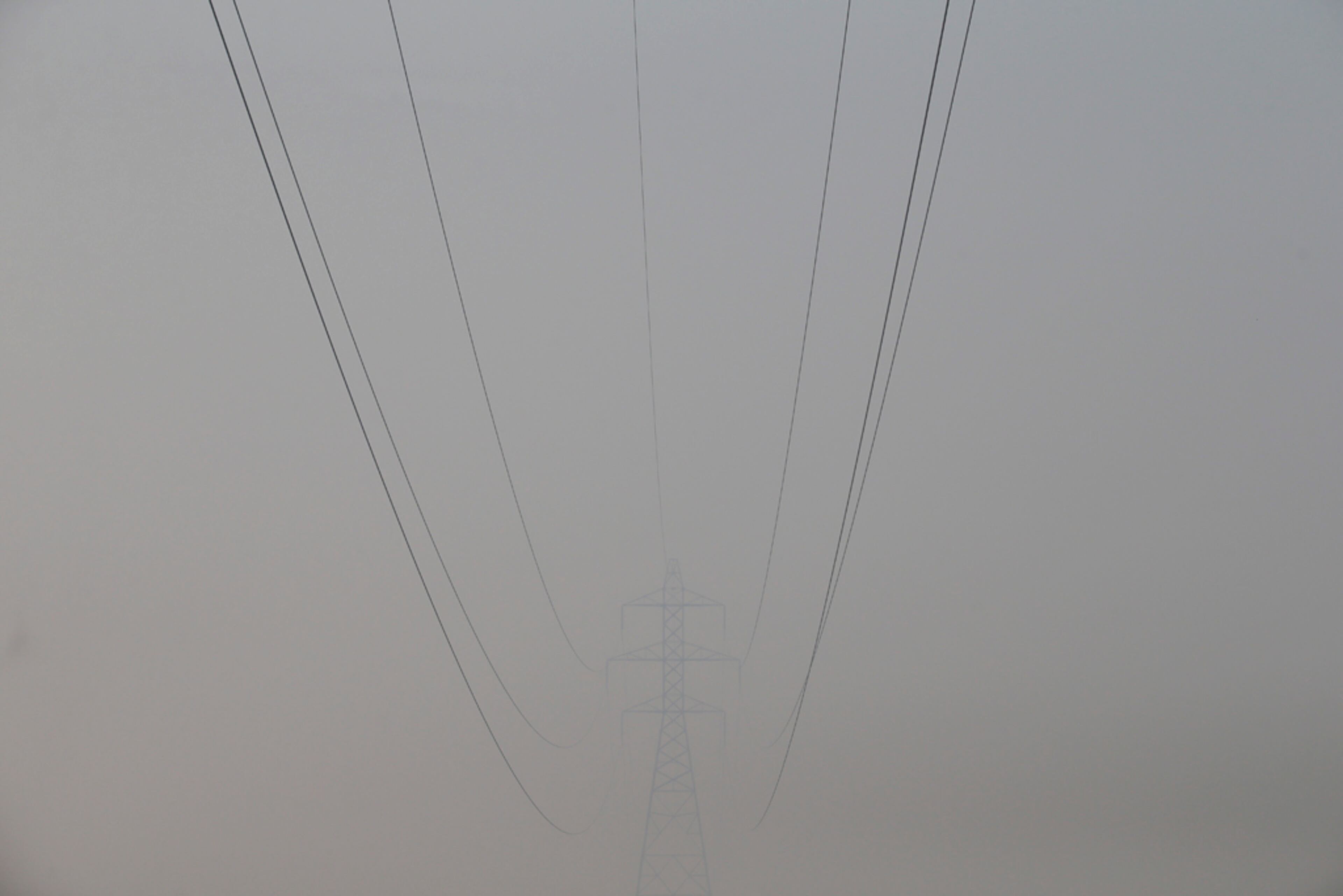 Power lines are faintly seen through the smoke generated by the Rim Fire near Yosemite National Park, Calif., on Sunday, Aug. 25, 2013. With winds gusting to 50 mph on Sierra mountain ridges and flames jumping from treetop to treetop, hundreds of firefighters have been deployed to protect this and other communities in the path of the Rim Fire raging north of Yosemite National Park. (AP Photo/Jae C. Hong)
