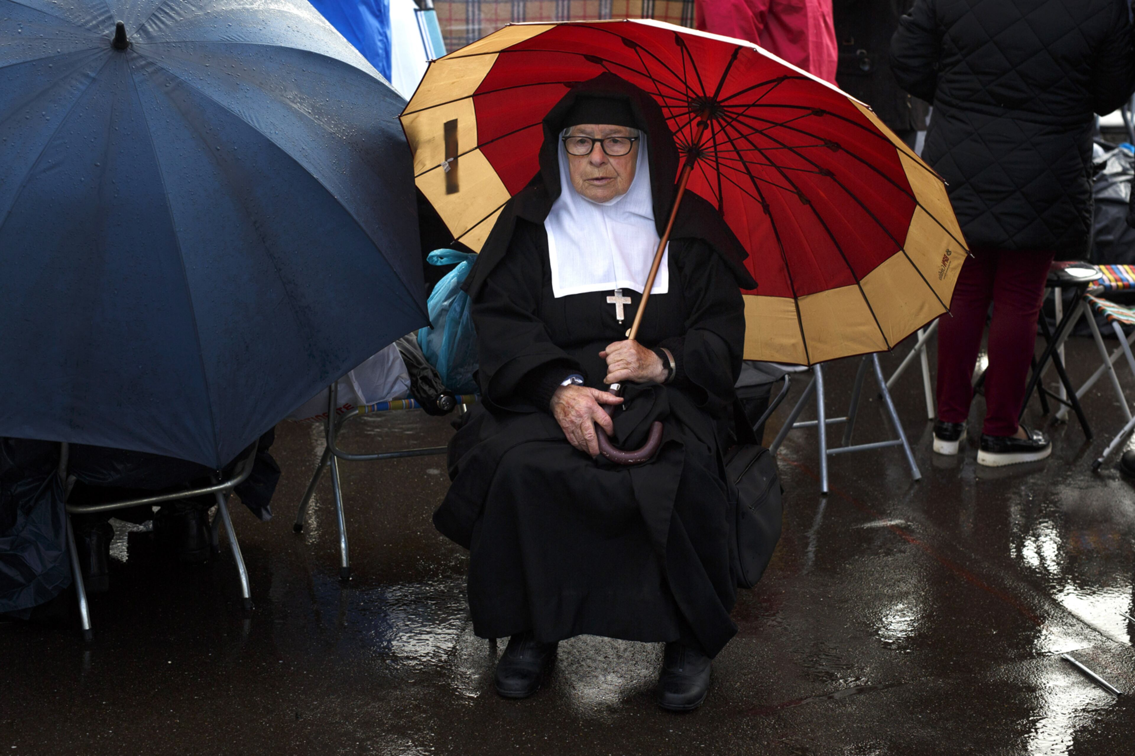 FATIMA, PORTUGAL - MAY 12: A nun covers from the rain with an umbrella as she waits for the arrival of Pope Francis in the Sanctuary of Fatima on May 12, 2017 in Fatima, Portugal. Pope Francis will be attending the Sanctuary of Fatima, in Portugal, on May 12 and 13 to canonize two Portuguese shepherds, Jacinta and Francisco Marto, who are said to have witnessed the apparition of what they believed was the Virgin Mary, together with their aunt Lucia Santos, during the 100 anniversary. Thousands of pilgrims and worshippers from around the world are expected to gather at the centenary celebration. (Photo by Pablo Blazquez Dominguez/Getty Images)