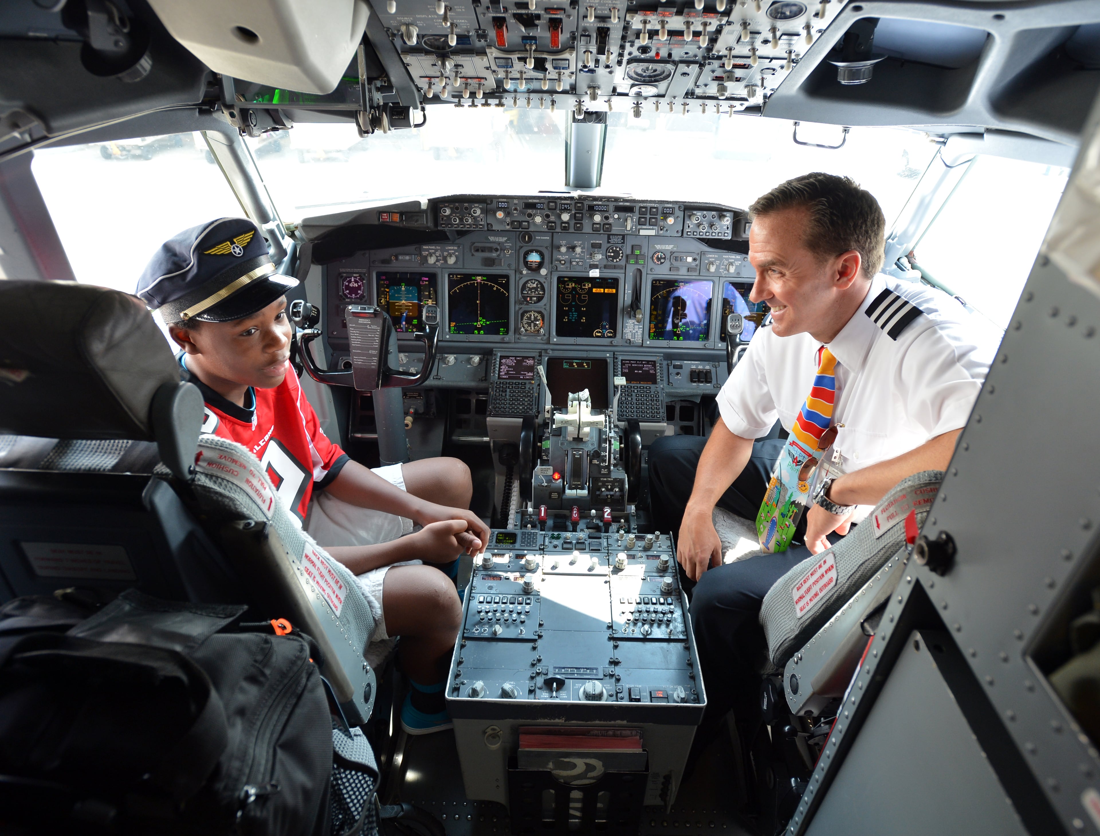 Jordan Thomas, 14, sits in the cockpit of a Southwest Airlines 737 with 1st Officer Ron Creel Tuesday September 10, 2013. Five members of the Atlanta Falcons visited Southwest Airlines operations at Hartsfield-Jackson Atlanta International Airport with special guest Jordan Thomas. Thomas, 14, was diagnosed with cancer in 2012. As part of the Make-A-Wish Foundation, Thomas had the opportunity to hang out with members of the Falcons as they visited the Southwest ticket counter terminal, announced a flight departure and helped direct a plane away from the terminal. BRANT SANDERLIN /BSANDERLIN@AJC.COM