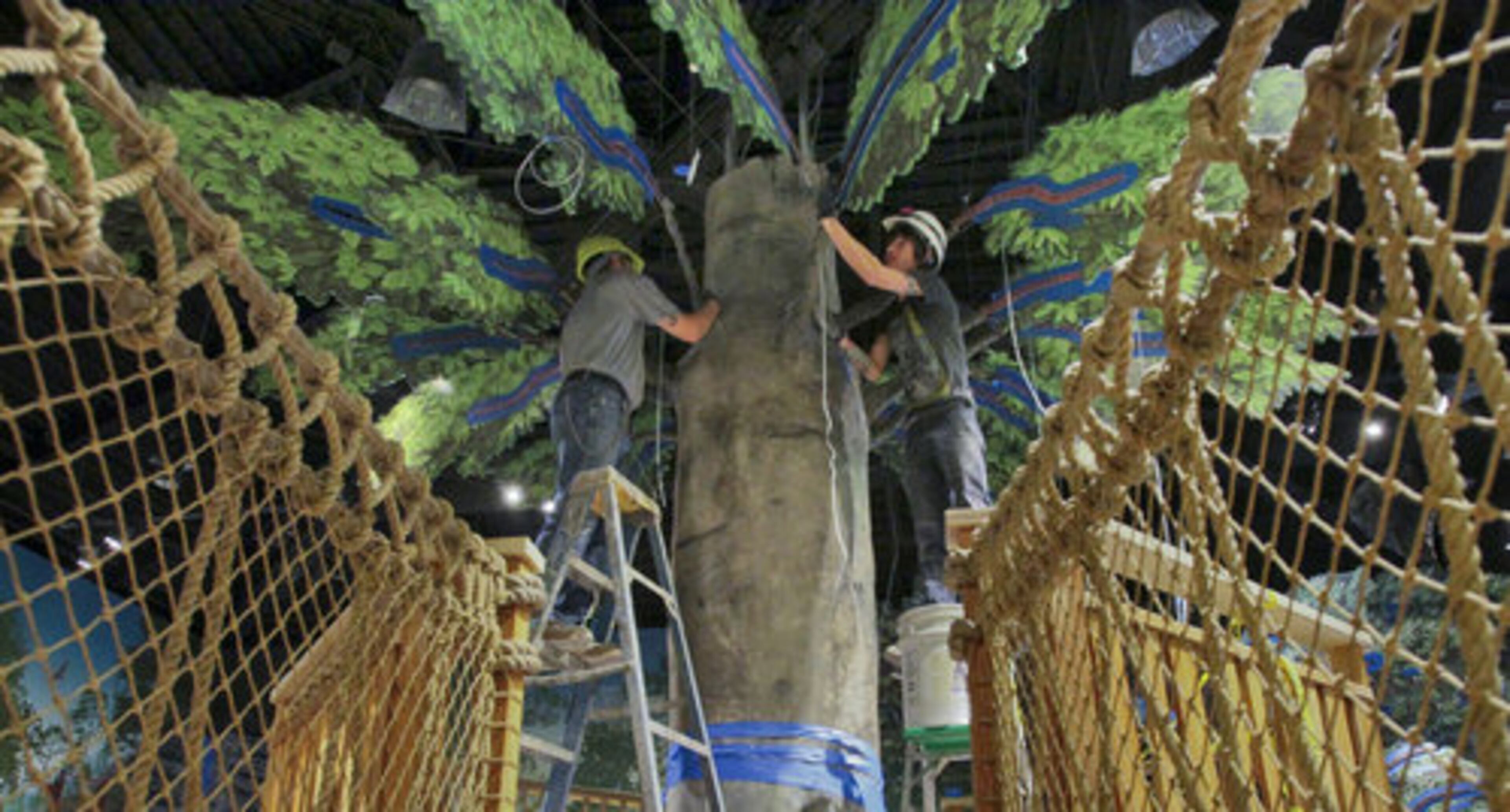 Brian Sullivan (left) and Stephen Hutton use a stucco mix to make the trunk and branches of a beech tree on an elevated deck.