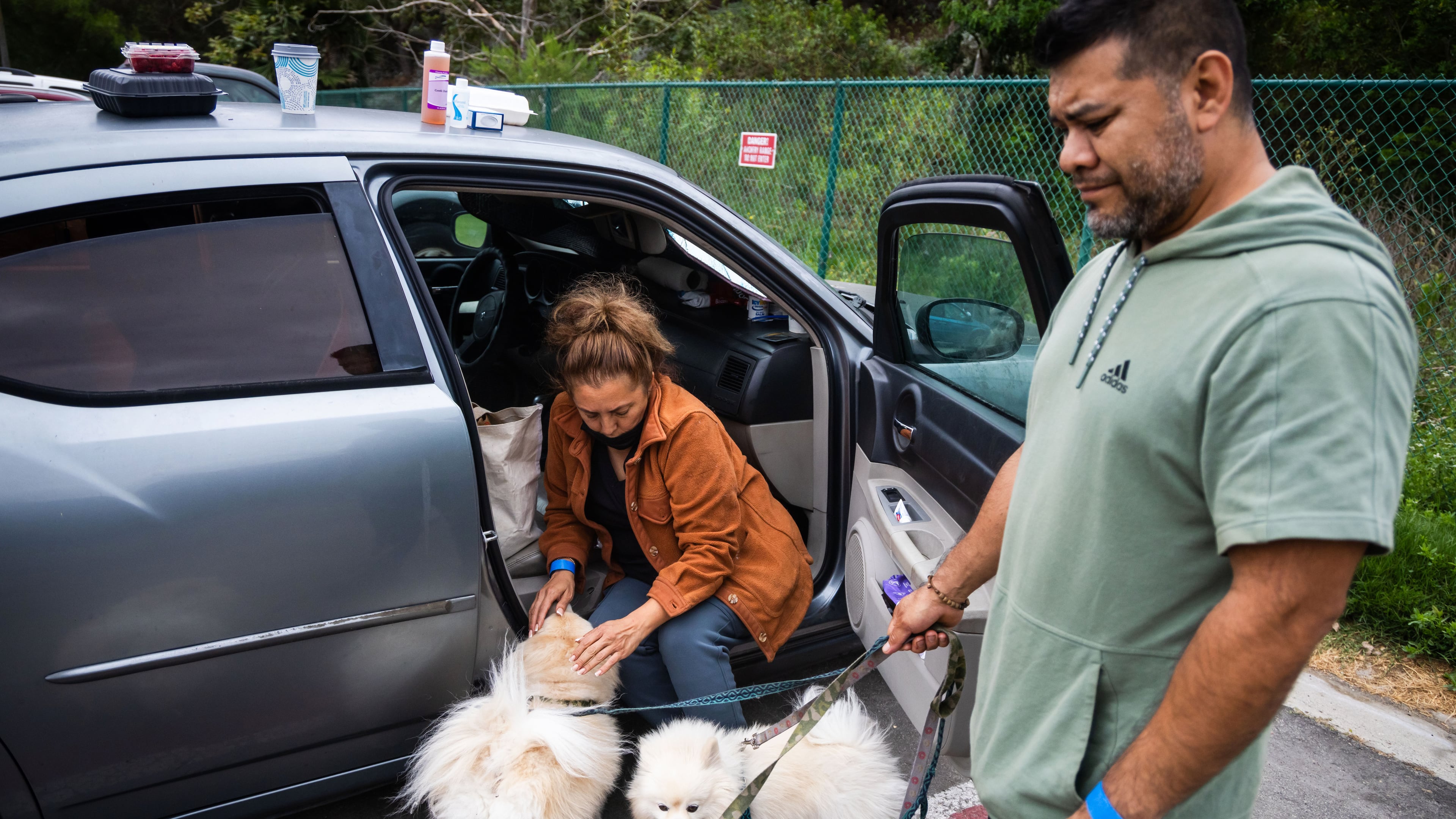 People tend to their pets outside Freedom Hall, an evacuation center in Fountain Valley, Calif., on Monday, May 25, 2026. (AP Photo/Ethan Swope)