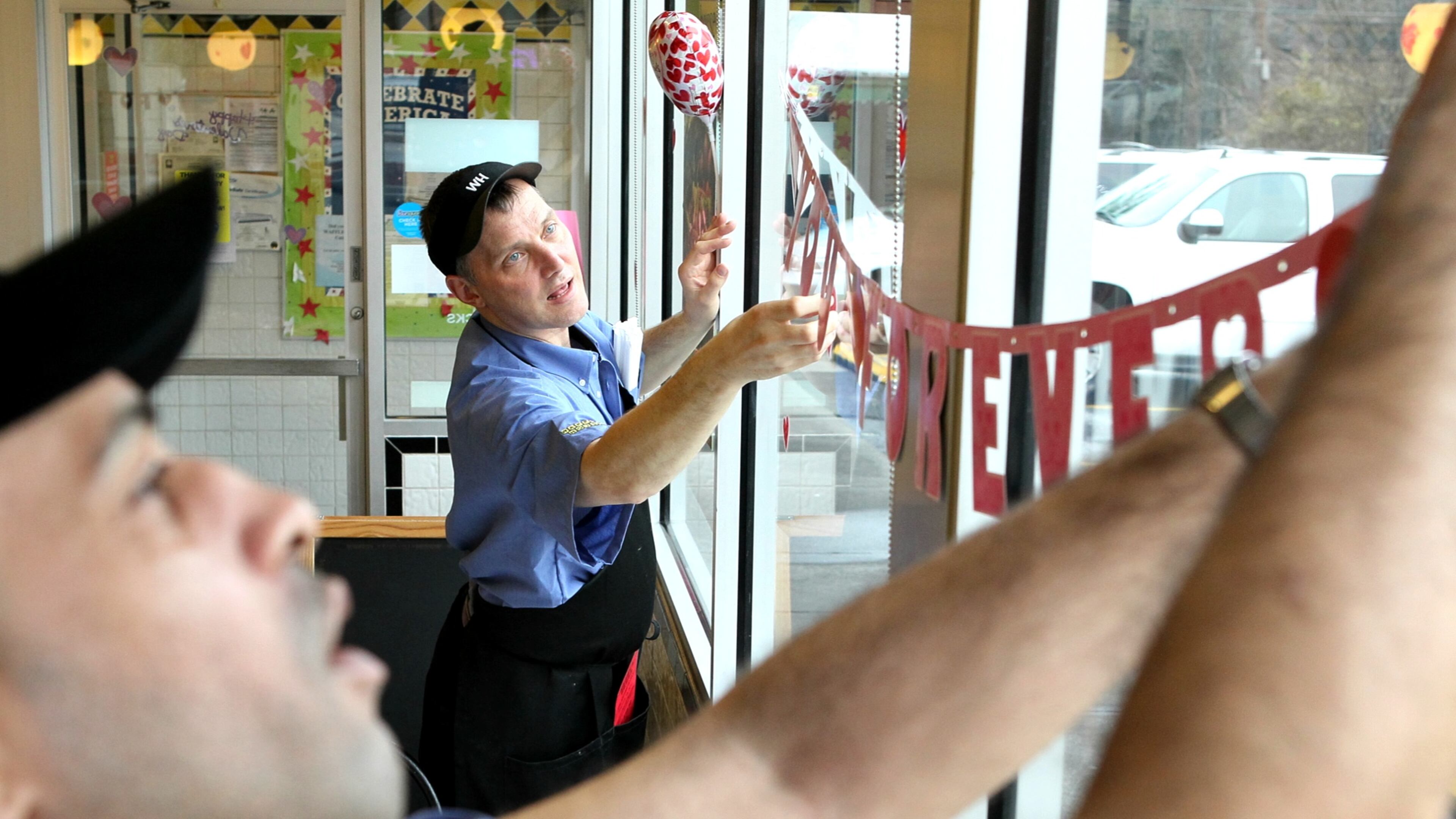 Pratis Boyd, left, and Eric Hoyle hang Valentine decorations at the Waffle House at Cheshire Bridge Road
in Atlanta where customers got an opportunity to have a very special
Valentine’s dinner back in 2012.