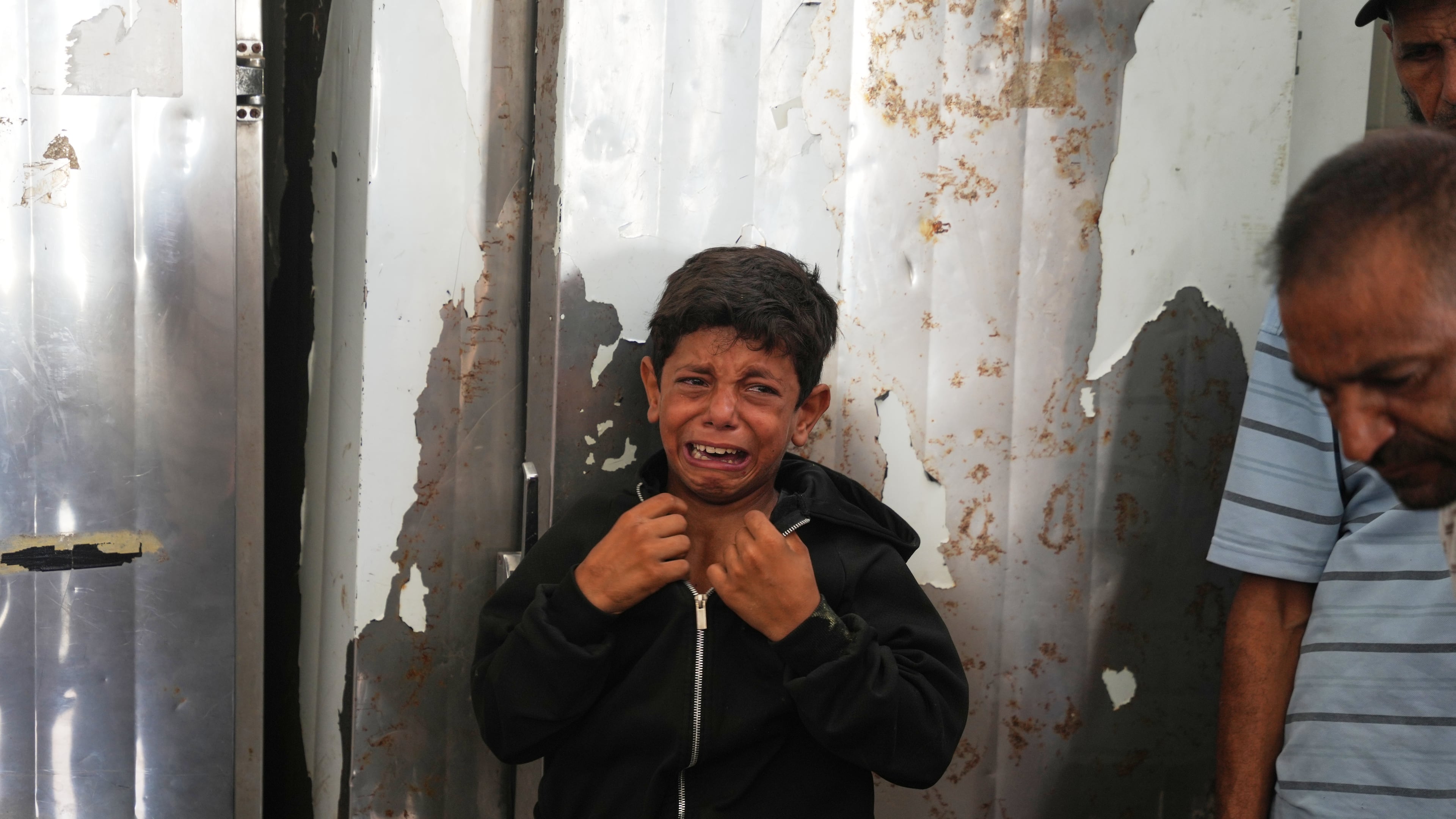 A Palestinian boy cries over the body of Hamouda al-Attar, who was killed by the Israeli army, during his funeral at al-Aqsa Hospital in Deir al-Balah, central Gaza Strip, Saturday, Aug. 29, 2026. (AP Photo/Abdel Kareem Hana)