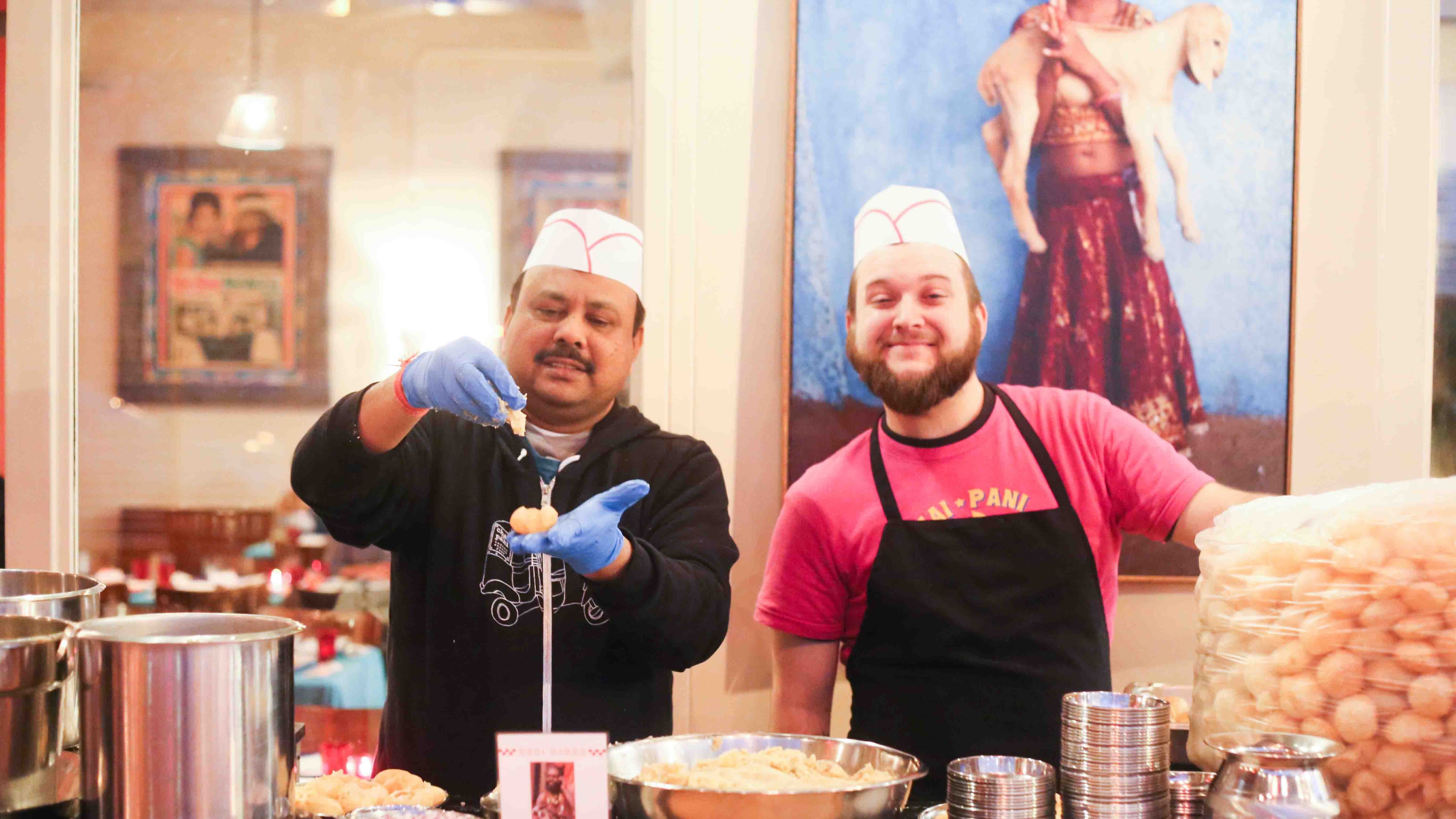 Vinod Singh Thakir (left) and Tony Varano of Chai Pani prepare pani puri, with a sackful of empty puri waiting to be filled.