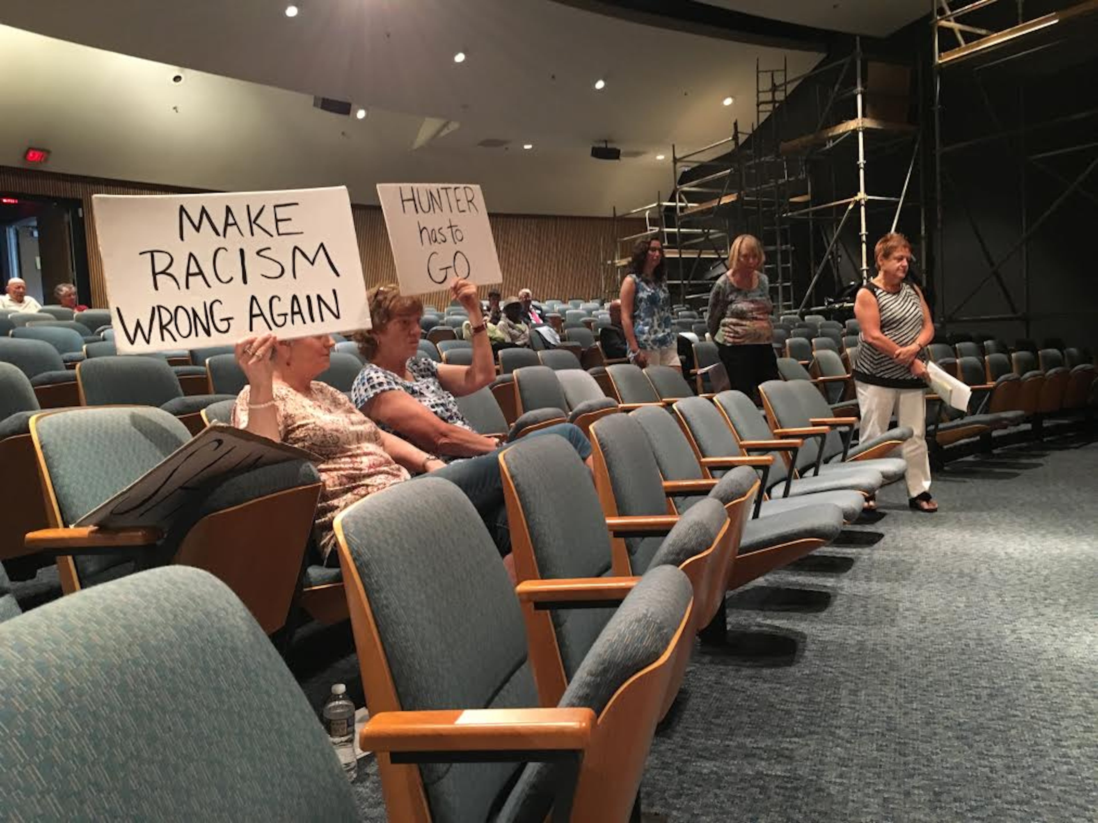 Protesters attend Tuesday afternoon’s meeting of the Gwinnett County Board of Commissioners to call for the resignation of Commissioner Tommy Hunter, who was reprimanded last week by his colleagues. TYLER ESTEP / TYLER.ESTEP@AJC.COM