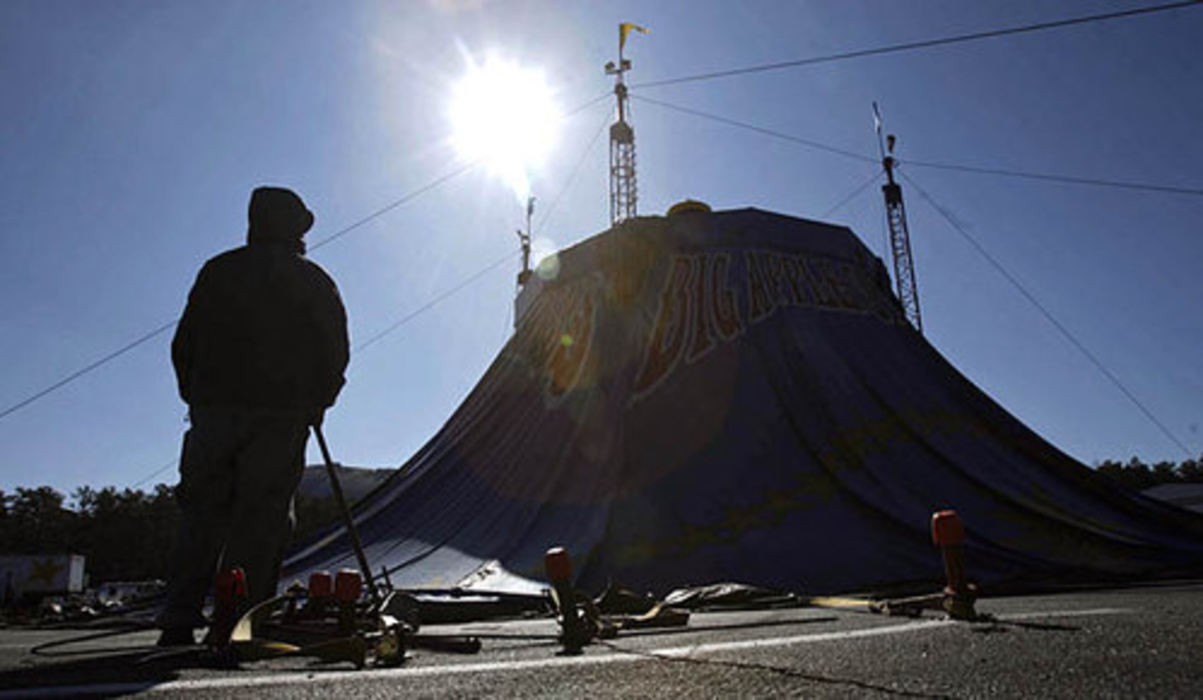 A member of the tent-raising crew watches as the center portion is raised to start the Big Apple Circus in Stone Mountain.