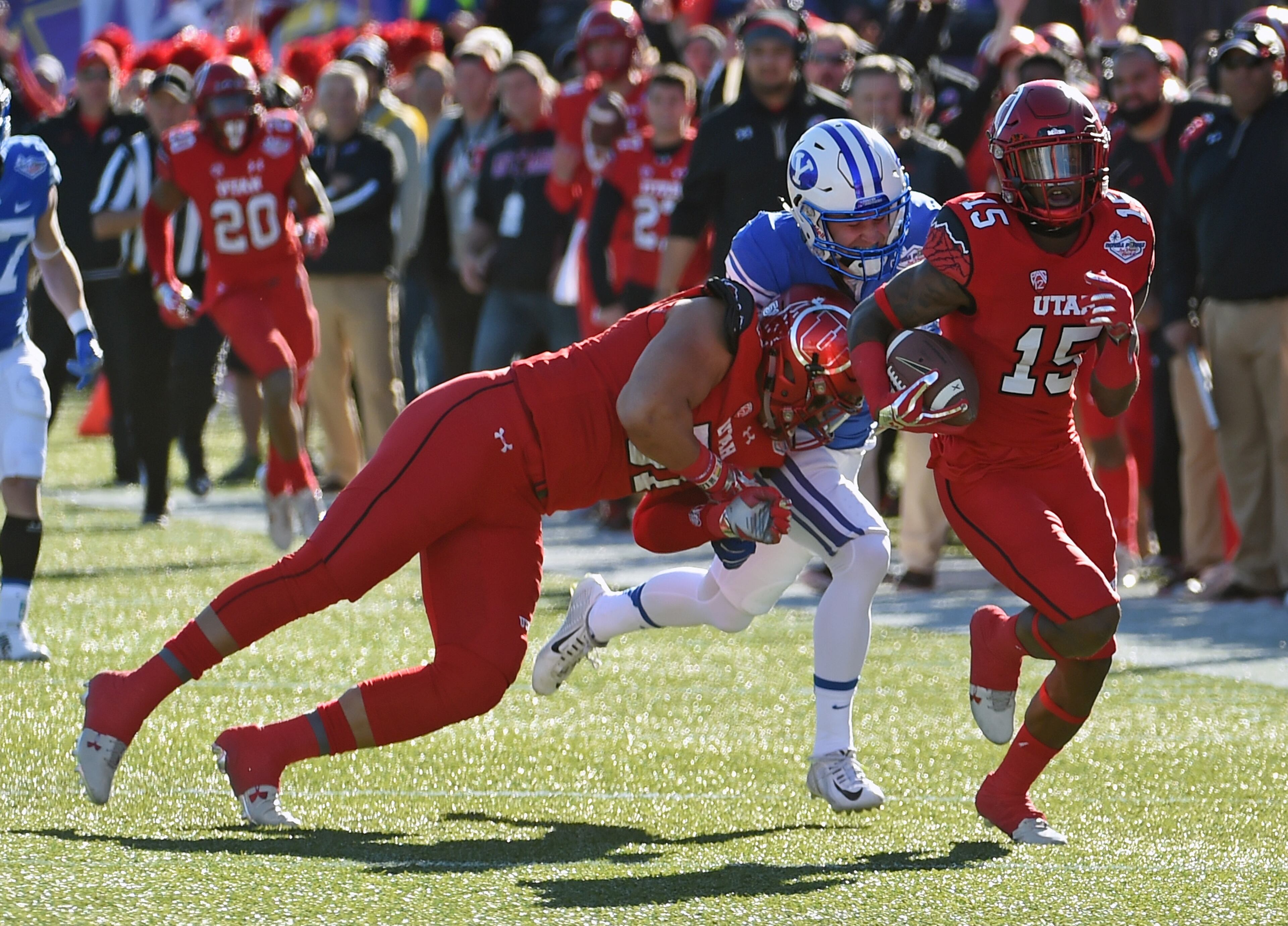 LAS VEGAS, NV - DECEMBER 19: Defensive back Dominique Hatfield #15 of the Utah Utes runs for a touchdown after intercepting a pass intended for wide receiver Kurt Henderson (C) #13 of the Brigham Young Cougars who is blocked by Jason Fanaika #51 of the Utes during the Royal Purple Las Vegas Bowl at Sam Boyd Stadium on December 19, 2015 in Las Vegas, Nevada. Utah won 35-28. (Photo by Ethan Miller/Getty Images)