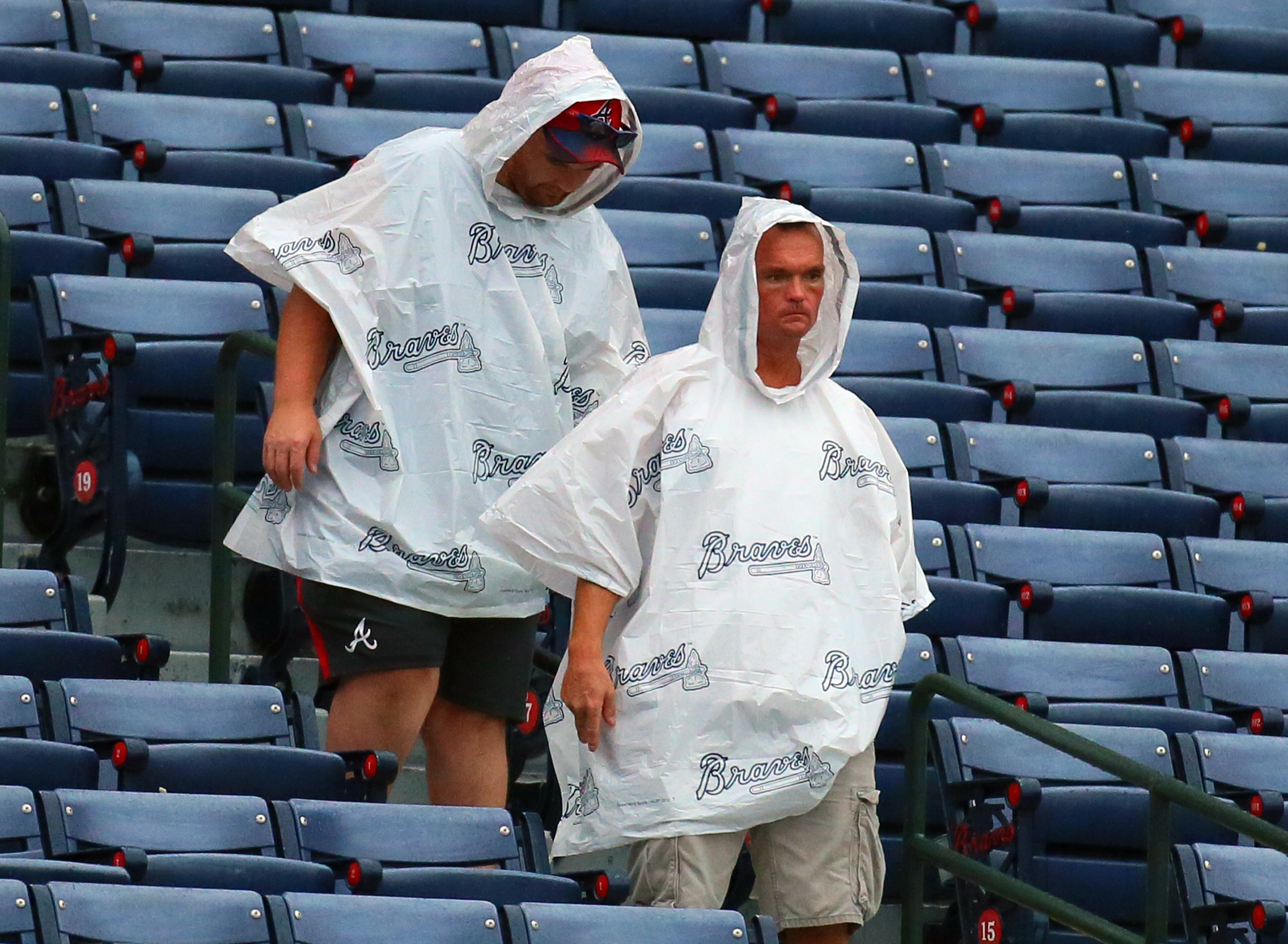 090113 Atlanta: - A couple of Braves fans brave the rain heading to their seats before the Braves play the Marlins on Sunday, Sept. 1, 2013, in Atlanta. CURTIS COMPTON / CCOMPTON@AJC.COM