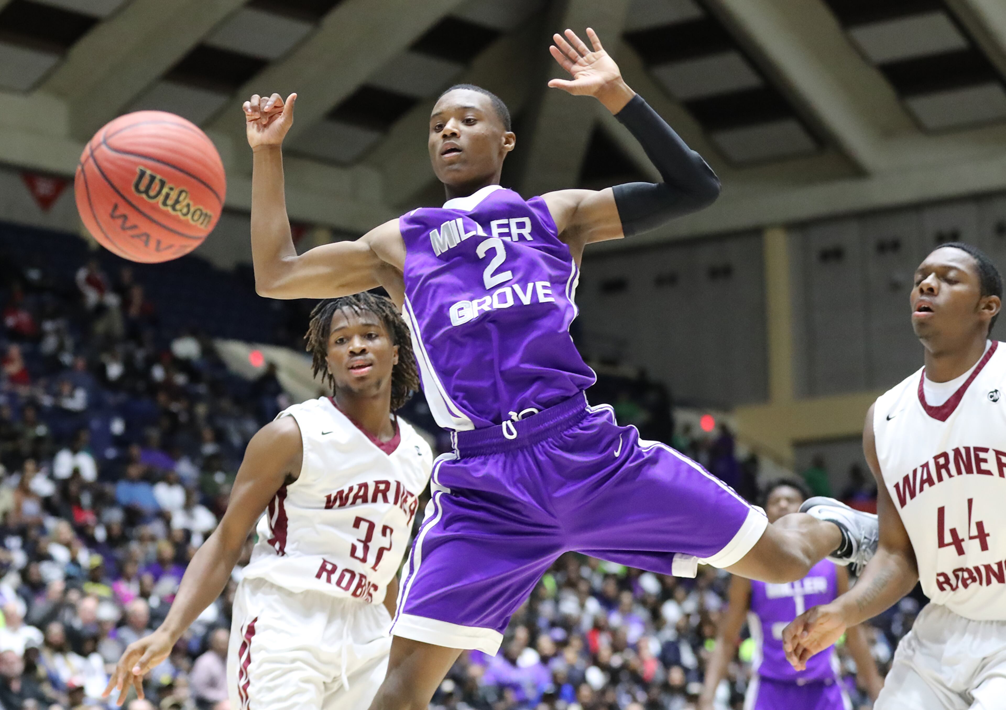March 8, 2018 Macon: Miller Grove guard Timothy Stargell Jr. loses the ball out of bounds as he collides with Warner Robins defender Trevon Williams in their GHSA state basketball championship game on Thursday, March 8, 2018, in Macon. Curtis Compton/ccompton@ajc.com