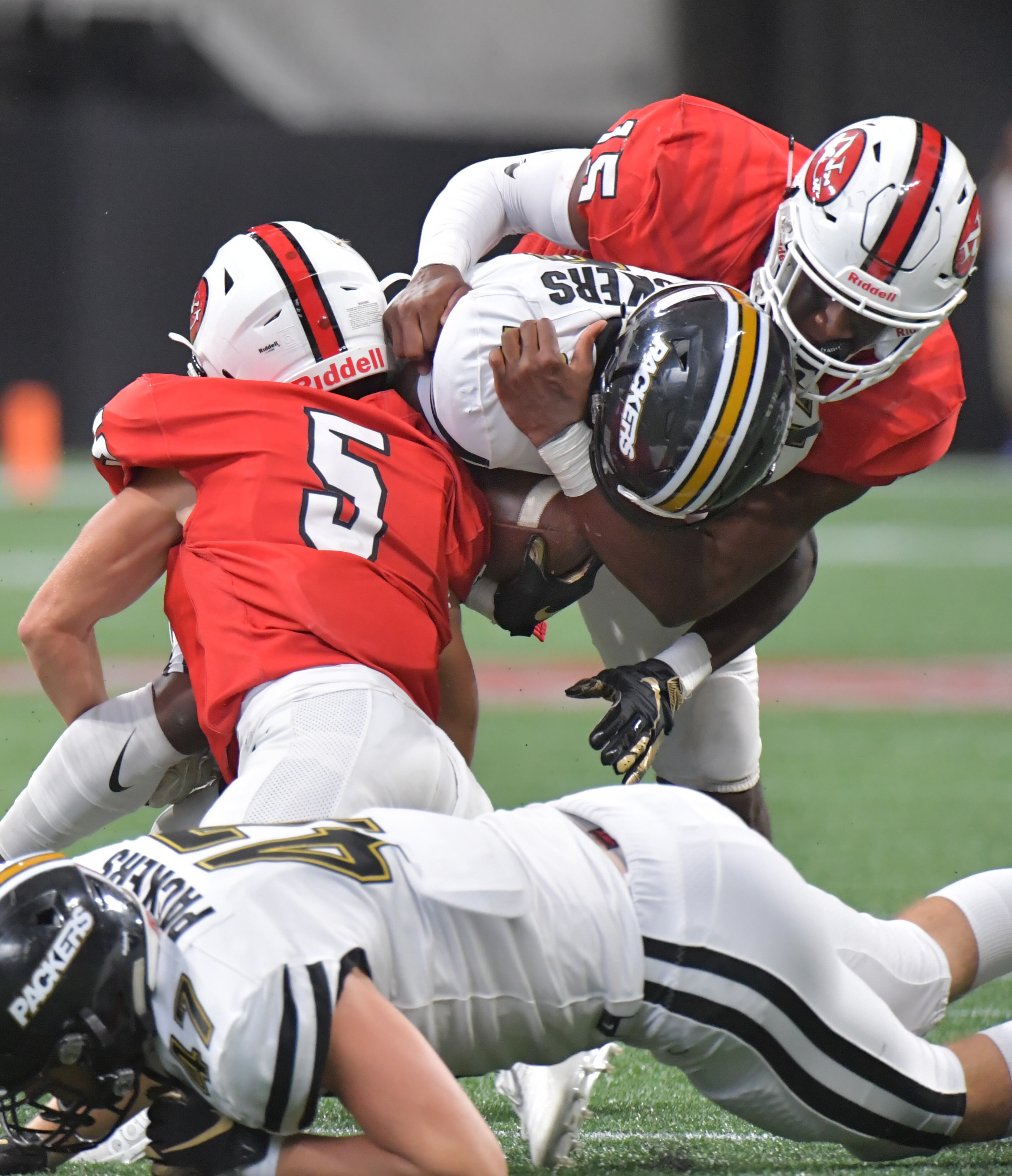 Colquitt County wide receiver Lemeke Brockington (17) gets tackled by North Gwinnett Jack Mcgill (5) and North Gwinnett defensive end Jared Ivey (15) in the second half during the Corky Kell Classic at Mercedes-Benz Stadium on Saturday, August 24, 2019. Colquitt County won 17- 6 over the North Gwinnett. (Hyosub Shin / Hyosub.Shin@ajc.com)
