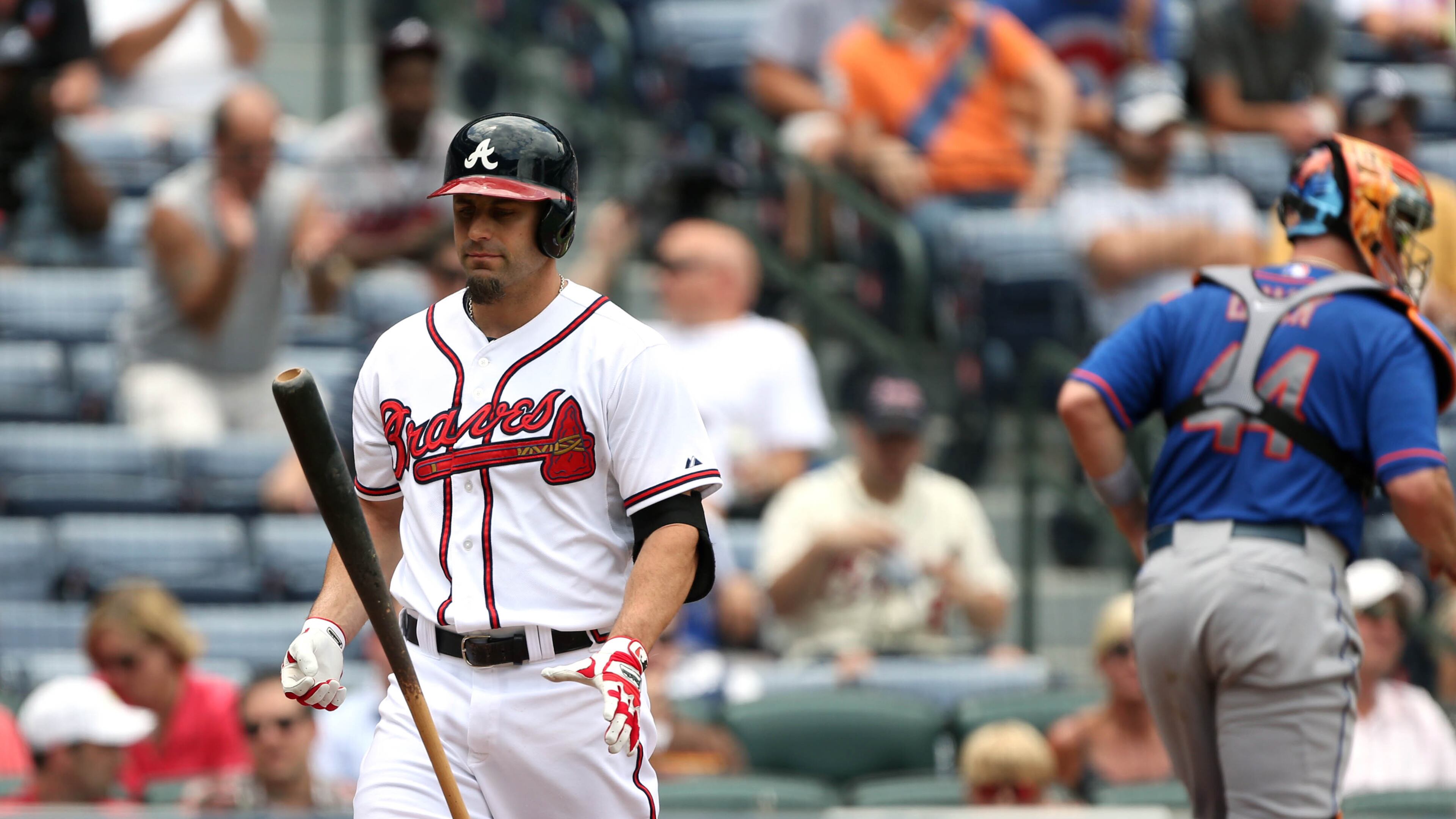 Atlanta Braves outfielder Reed Johnson, left, flips his bat after striking out to end the third inning with Braves in scoring position as New York Mets catcher John Buck goes to the dugout. JASON GETZ / JGETZ@AJC.COM