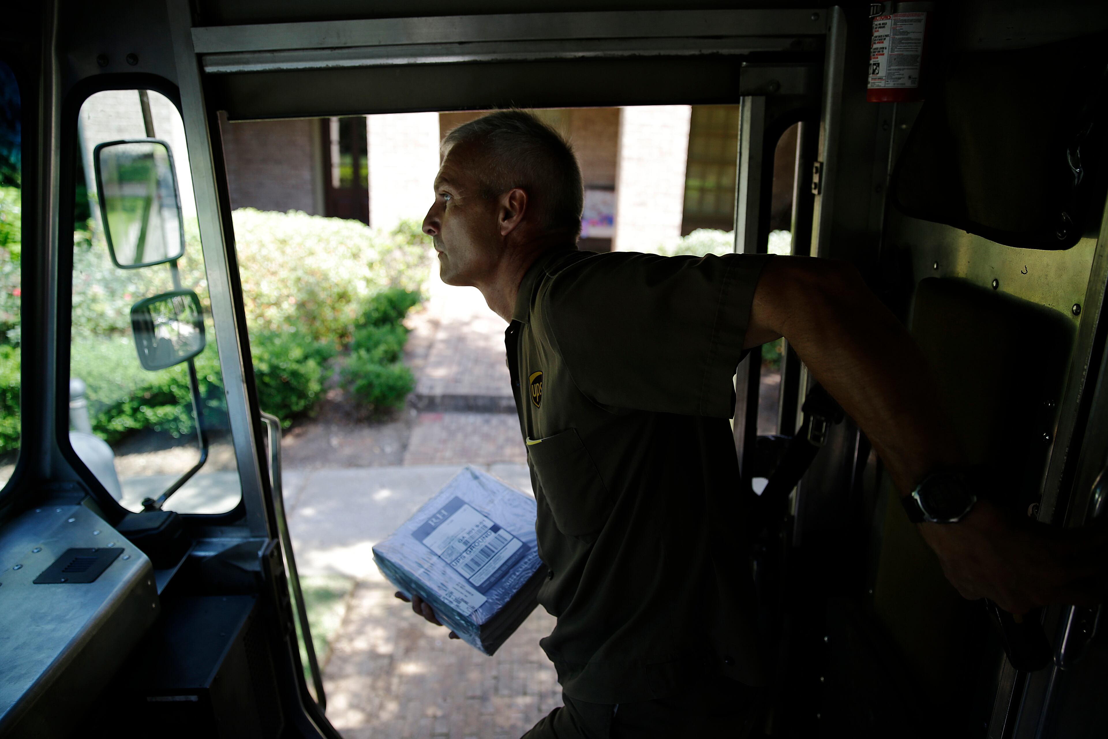 In this June 20, 2014 photo, United Parcel Service driver Marty Thompson makes a delivery in Cumming, Ga. (AP Photo/David Goldman)