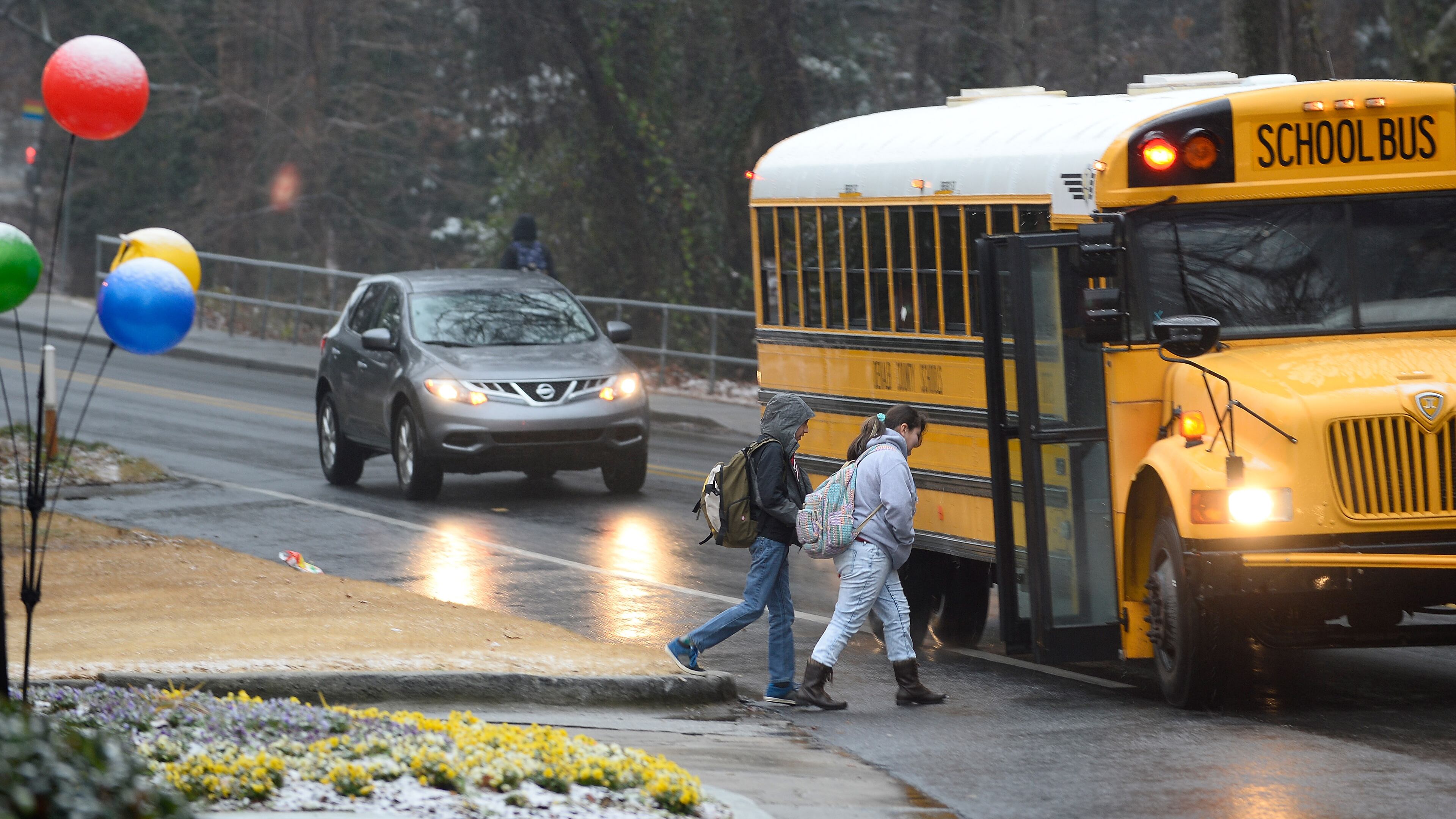 DeKalb County students board a bus during a wintry mix of snow, sleet and rain, Tuesday, Feb. 24, 2015, in Atlanta. The University of Georgia's Gwinnett campus delayed their opening while further west, the Cobb County school system canceled classes and weather forecasters predicted another round of winter weather for Wednesday. (AP Photo/David Tulis)