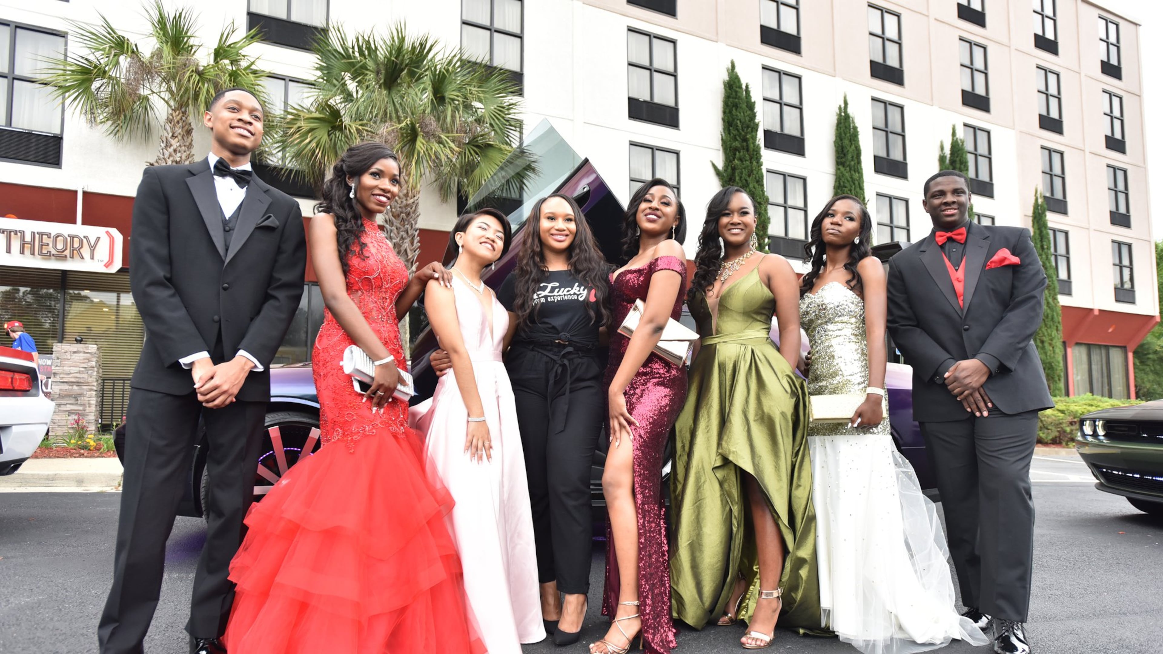 Keana Millar (center) poses with students (from left) Chauncey Holt, Lajoie Mukuba, Bawi Parr, Bridget Wilson, Rayanna Vilera, Nyota Mukuba and Jevon Calvin before they leave for their prom on May 4. Millar is founder of Lucky 7 Prom Experience. HYOSUB SHIN / HSHIN@AJC.COM