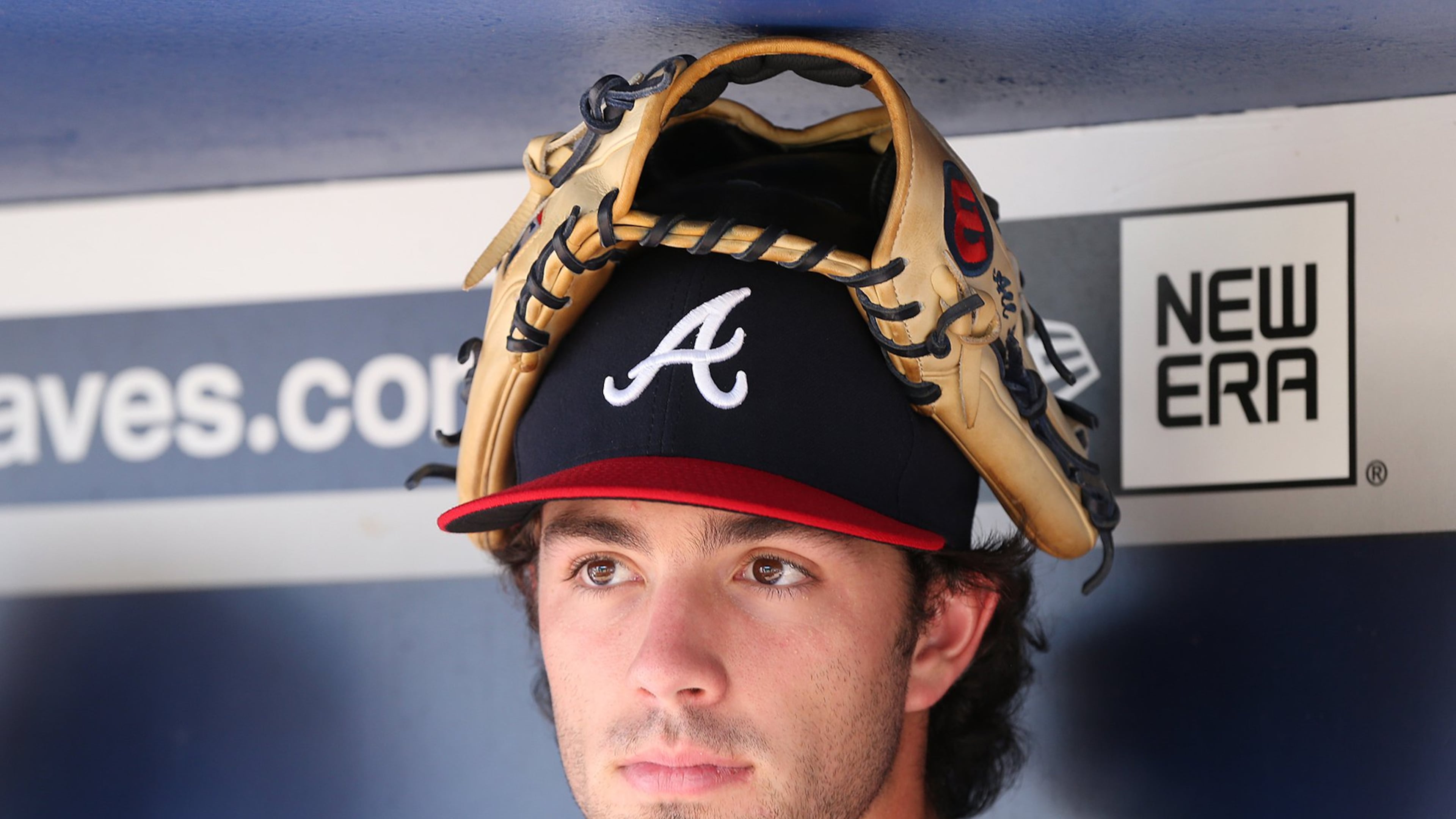 Dansby Swanson in repose in the Braves dugout, before employing his glove in a more conventional manner. (Curtis Compton /ccompton@ajc.com)