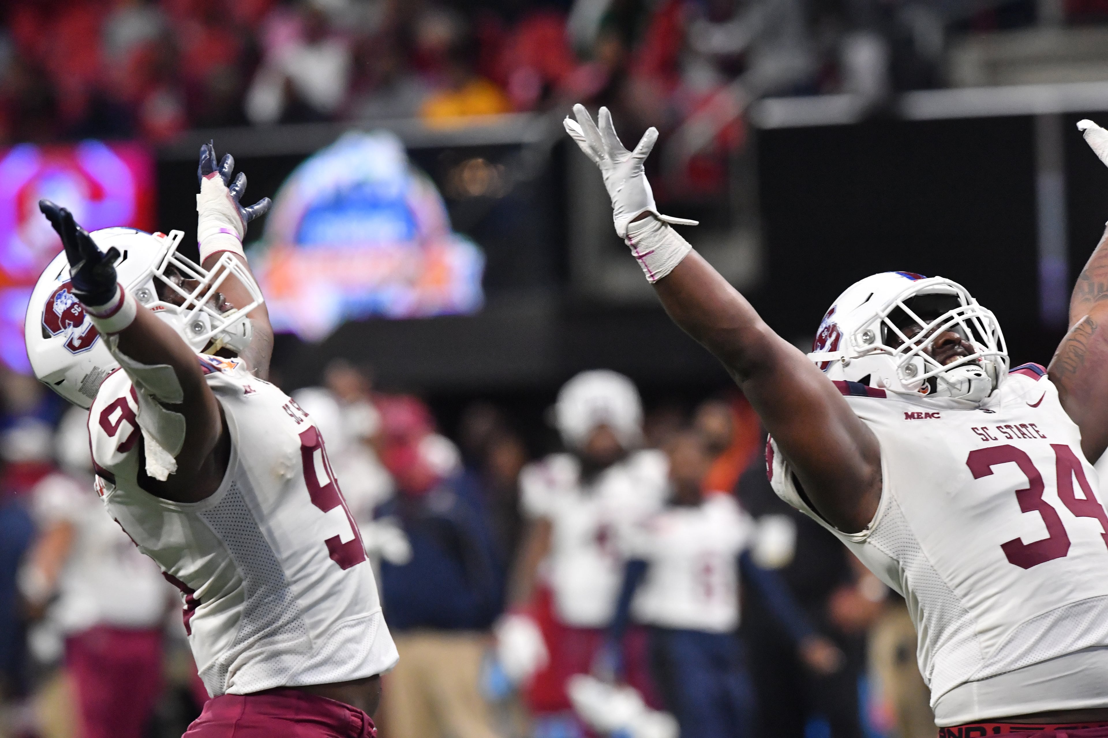 South Carolina State's defensive lineman Shaeem Haltiwanger (96) and South Carolina State's linebacker Jablonski Green (34) celebrate during the second half of the 2021 Cricket Celebration Bowl at Mercedes-Benz Stadium in Atlanta on Saturday, December 18, 2021. South Carolina State won 31-10 over Jackson State. (Hyosub Shin / Hyosub.Shin@ajc.com)