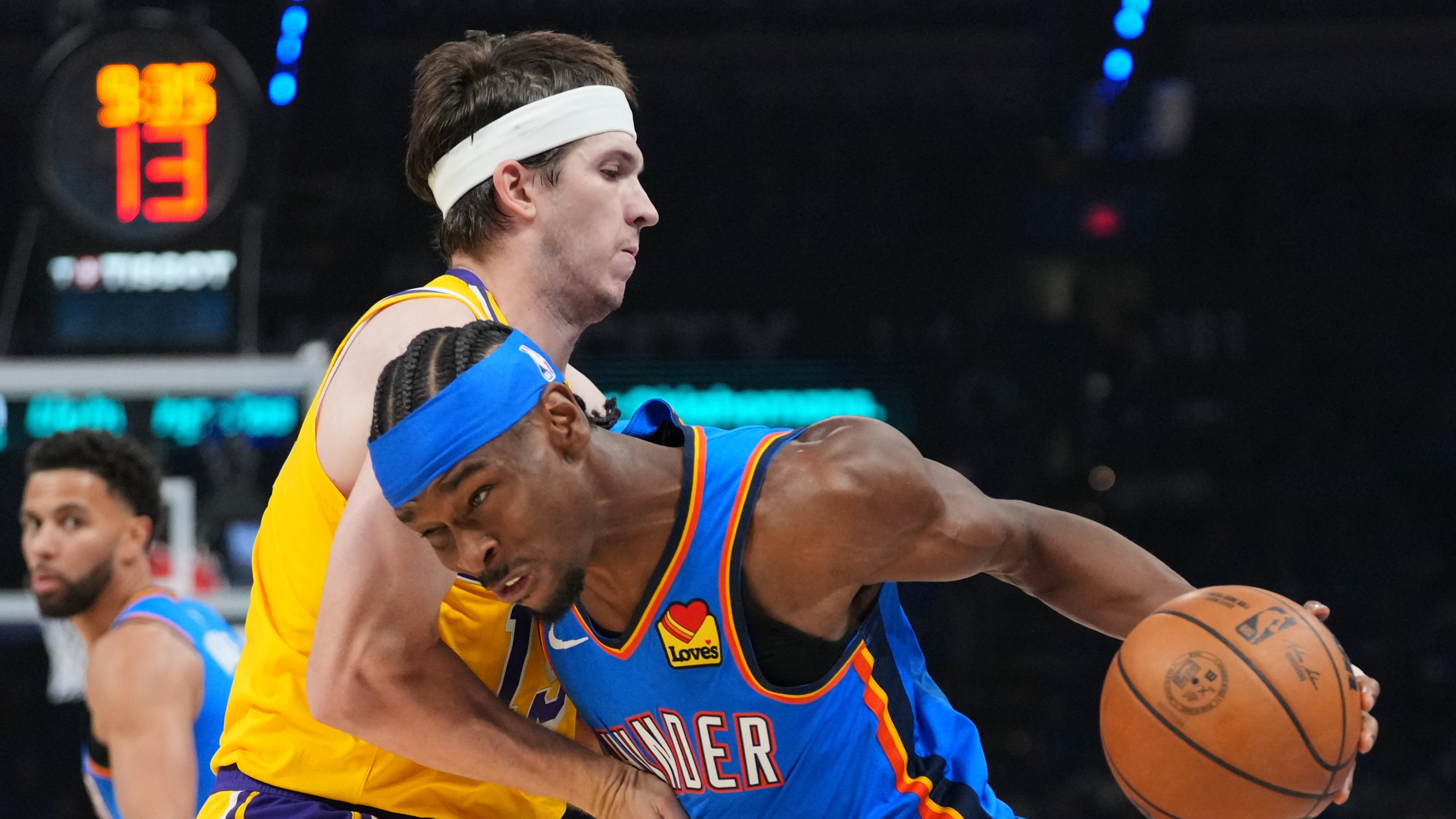 Oklahoma City Thunder guard Shai Gilgeous-Alexander, right, drives to the basket as Los Angeles Lakers guard Austin Reaves, left, defends second half of Game 1 in a second-round NBA basketball playoffs series Tuesday, May 5, 2026 in Oklahoma City. (AP Photo/Kyle Phillips)