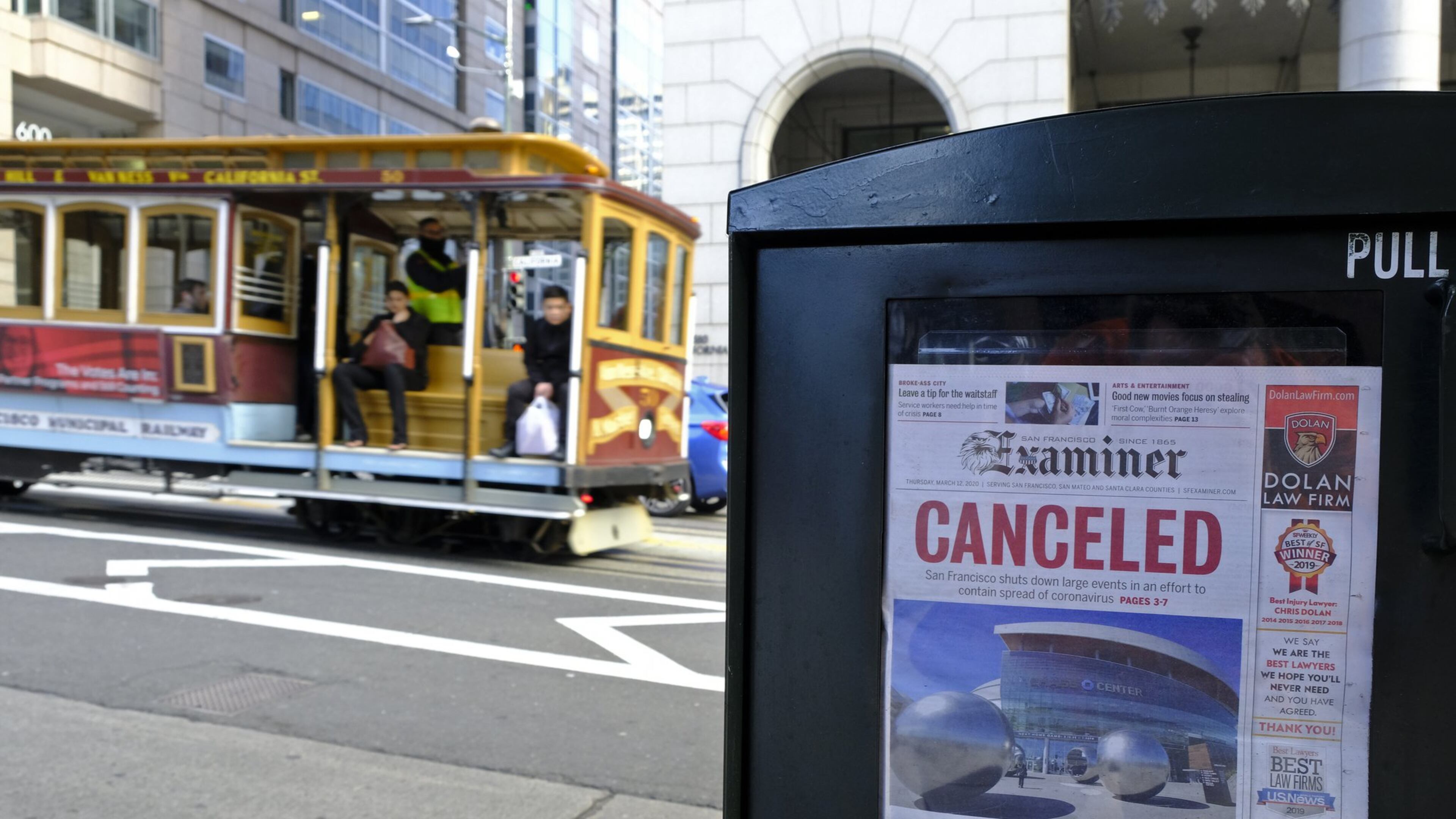 A newspaper headline announcing the closure of large events is displayed Friday, March 13, 2020, in San Francisco. A wave of closures and postponements spanning everything from government offices to cultural events and sports followed concerns of the coronavirus’ spread. (AP Photo/Eric Risberg)