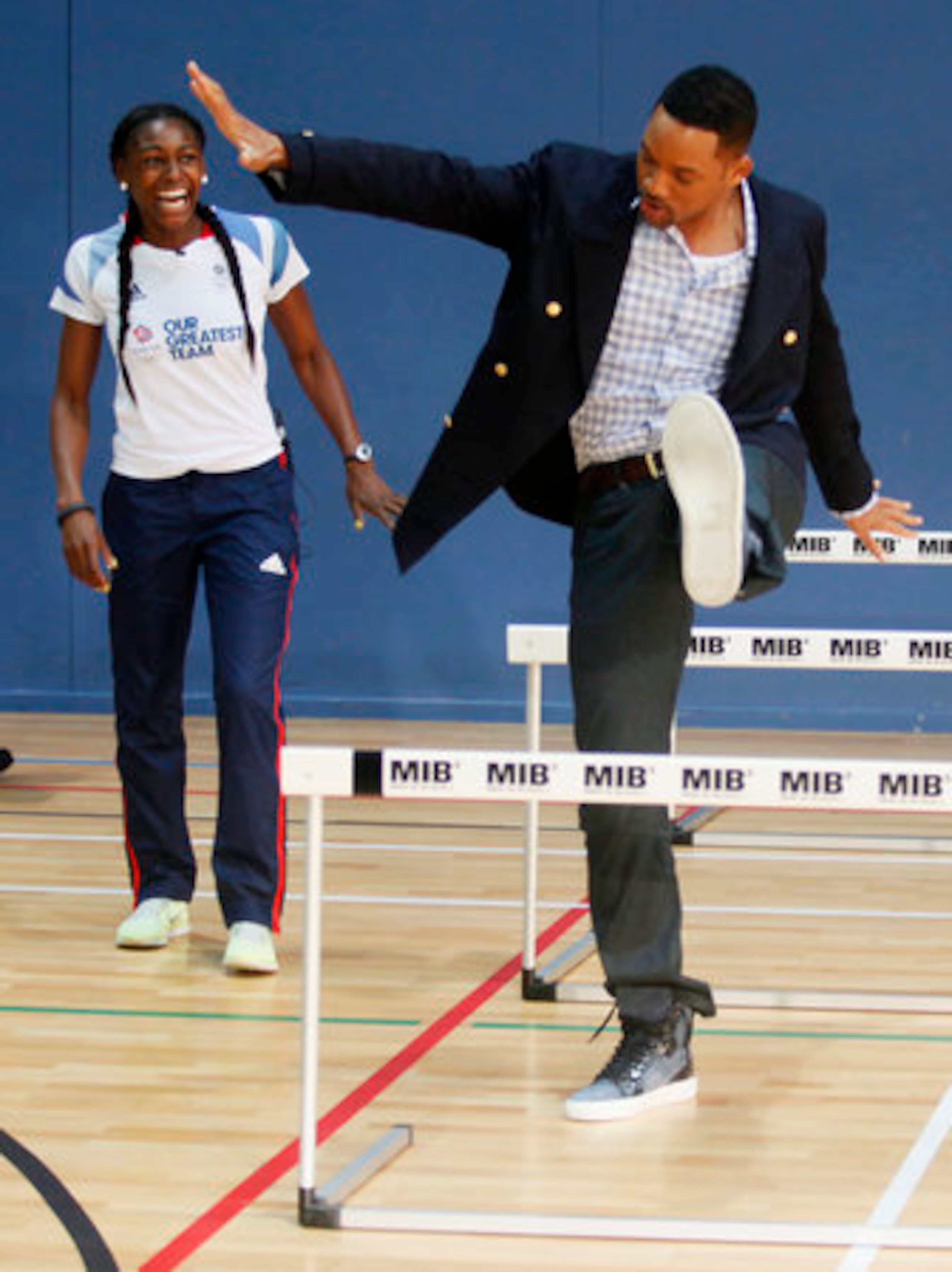 Will Smith takes direction from Great Britain Olympic 400m hurdler Perri Shakes-Drayton and gingerly steps over the hurdle.