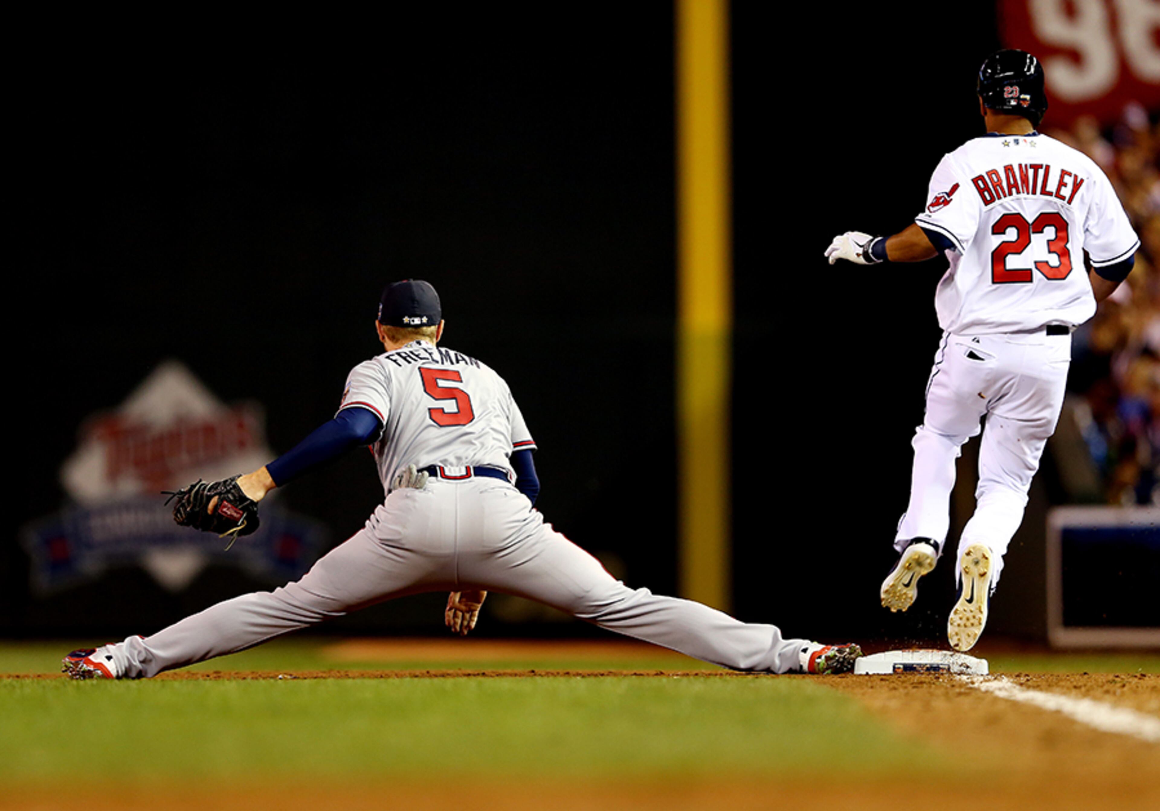 Atlanta Braves first baseman Freddie Freeman stretches to make a catch as American League All-Star Michael Brantley #23 of the Cleveland Indians runs to first base during the 85th MLB All-Star Game at Target Field on July 15, 2014 in Minneapolis, Minnesota.
