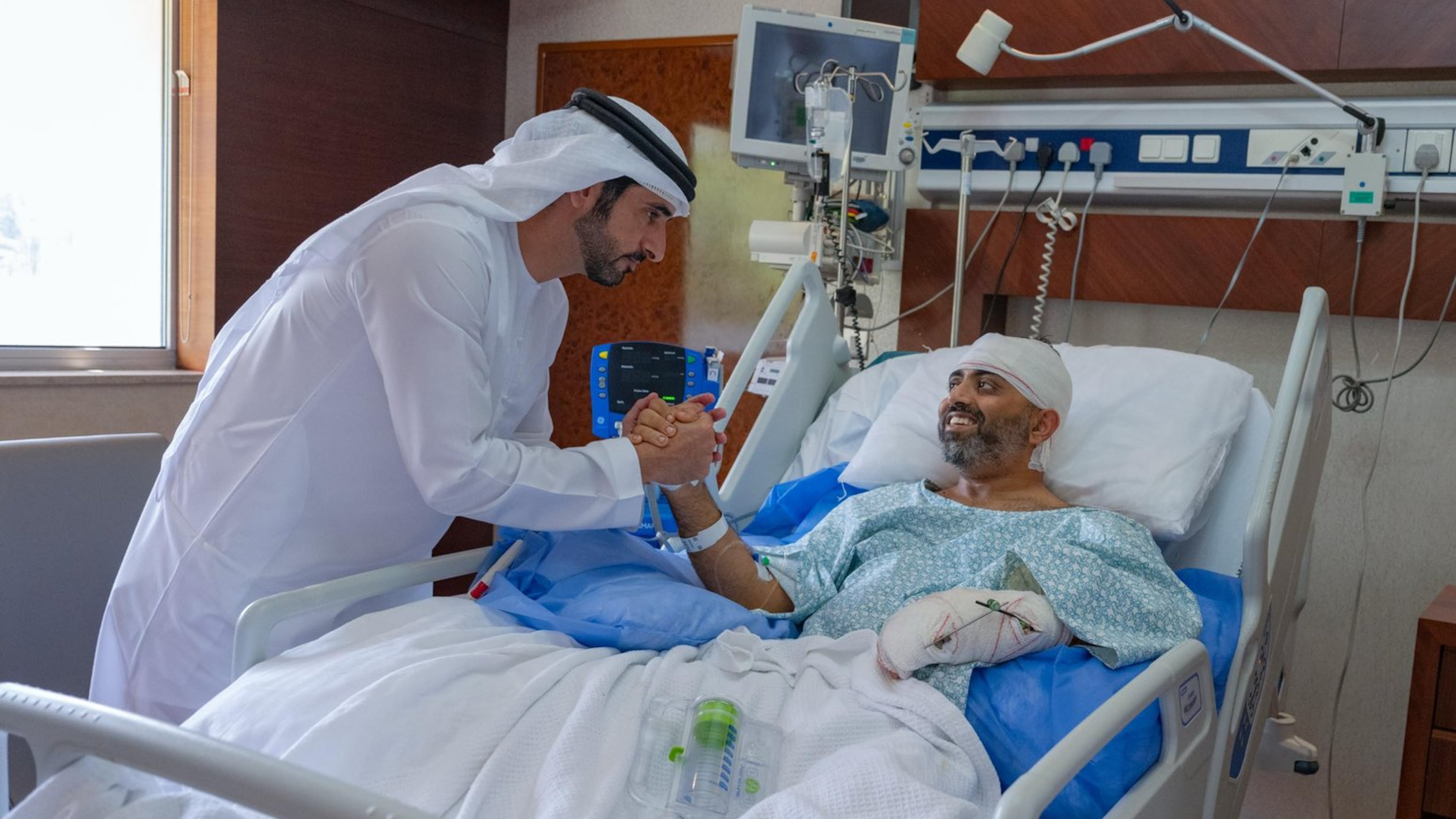 In this photo provided by the Government of Dubai Media Office, Dubai Crown Prince Sheikh Hamdan bin Mohammed bin Rashid Al Maktoum, left, visits injured Indian Flydubai Capt. Smit Machchhar at a hospital in Abu Dhabi, United Arab Emirates, Friday, Oct. 2, 2026. (Government of Dubai Media Office via AP)